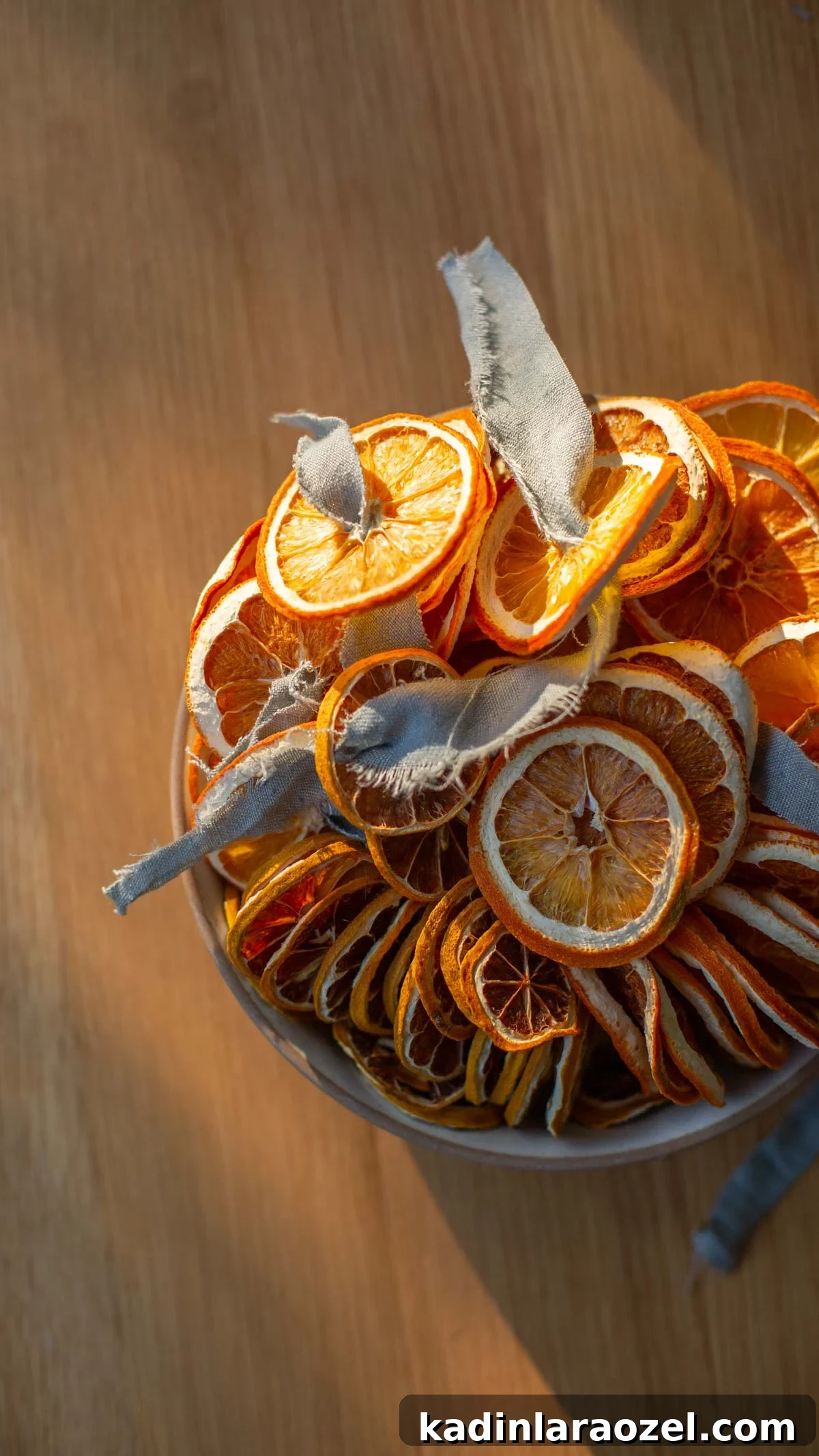 large bowl filled with dried orange slices, sitting in the sun