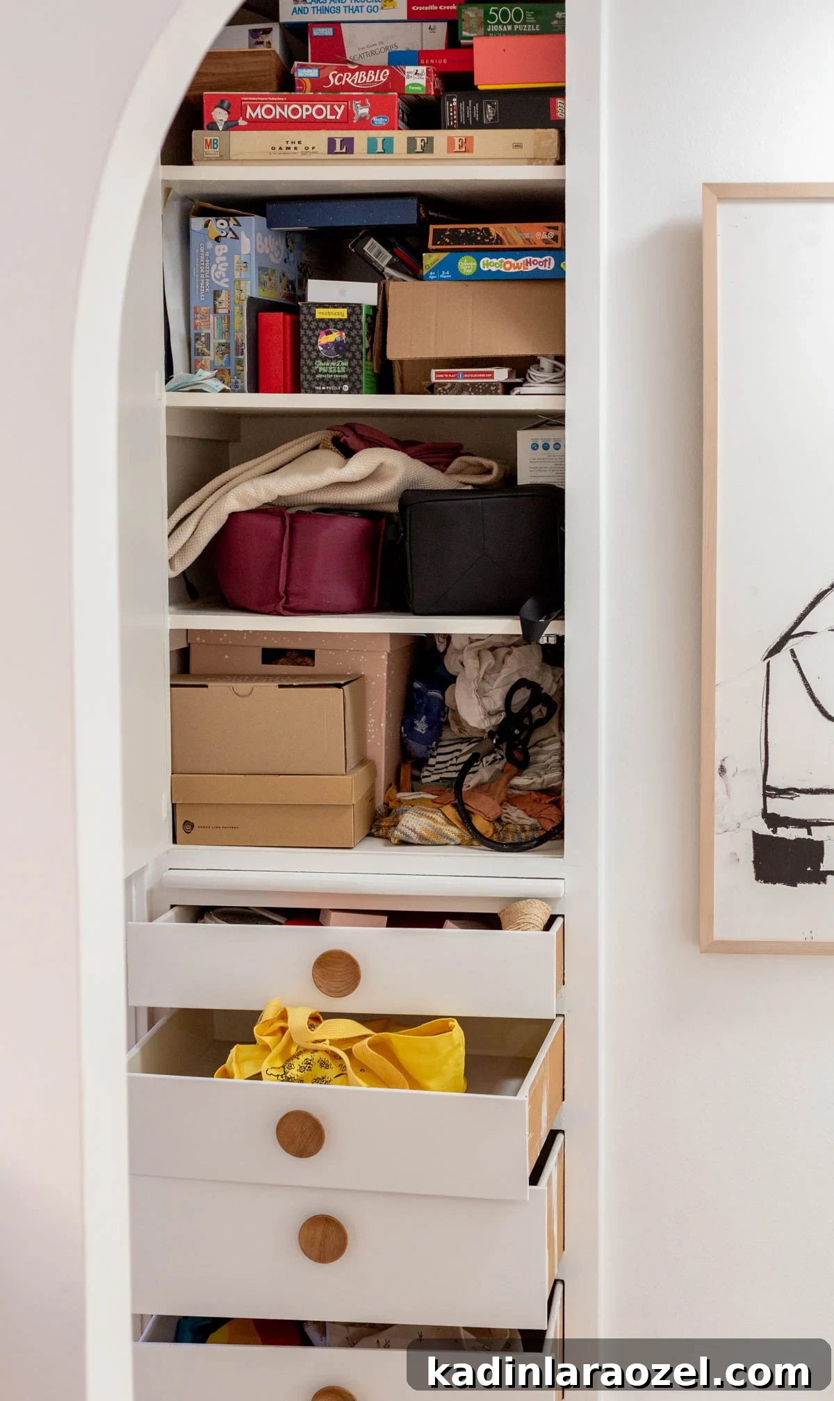 Messy hall closet completely filled with stuff and opened drawers with items coming out of them