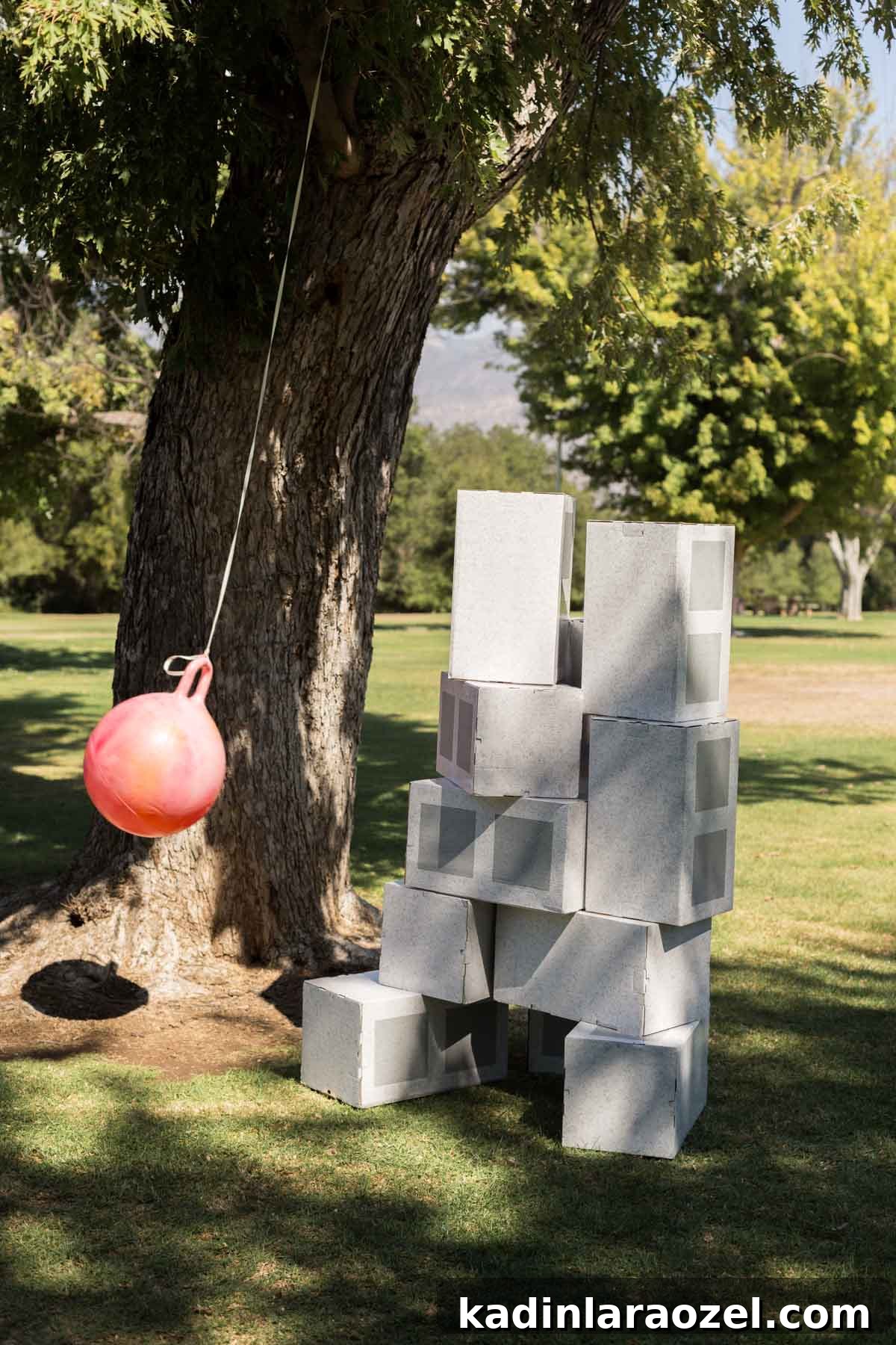 Construction and Car-Themed Birthday Party Ideas for Kids 7 pink wrecking ball tied to a tree branch, wrecking through cardboard blocks at a construction themed birthday party for kids
