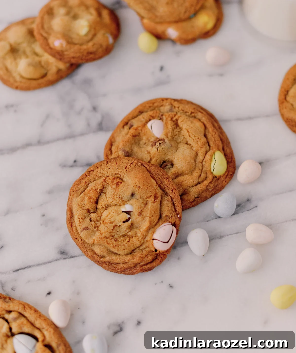 Cadbury Chocolate Chip Cookie Recipe — Chewy, Chocolatey Treats 3 pile of cadbury chocolate chip cookies for easter with pastel colored easter candy inside, sitting on marble counter