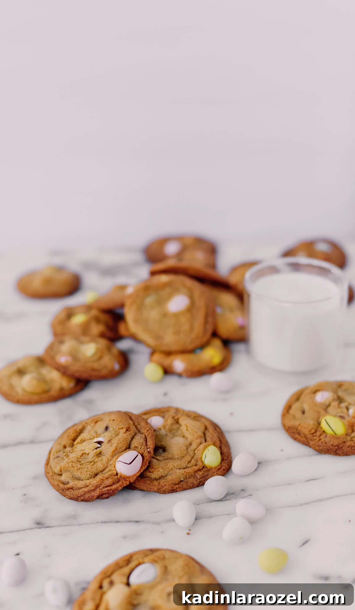 Cadbury Chocolate Chip Cookie Recipe — Chewy, Chocolatey Treats 6 cookies on a marble counter with easter candy and glass of milk