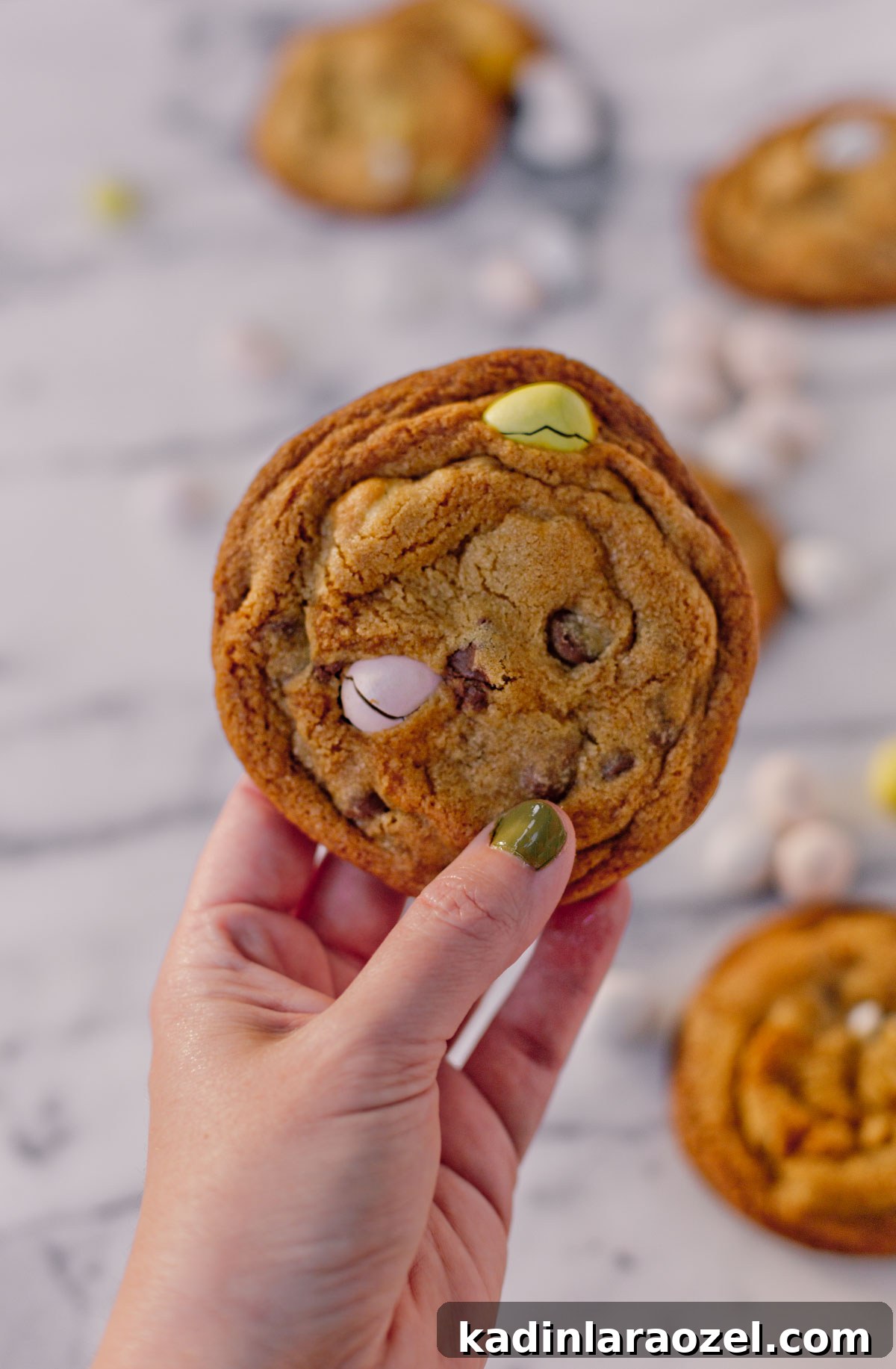 Cadbury Chocolate Chip Cookie Recipe — Chewy, Chocolatey Treats 7 woman holding cookie with easter candy and chocolate chips in it