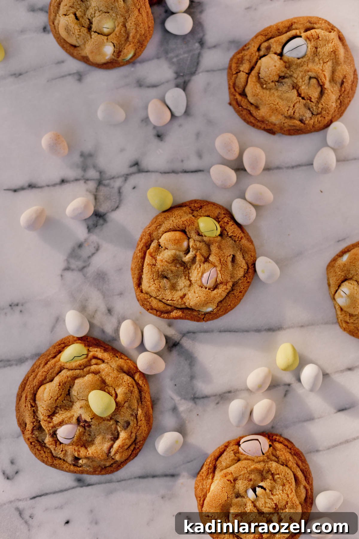 Cadbury Chocolate Chip Cookie Recipe — Chewy, Chocolatey Treats 9 Cadbury chocolate chip cookies laid out on a marble counter with candy around it