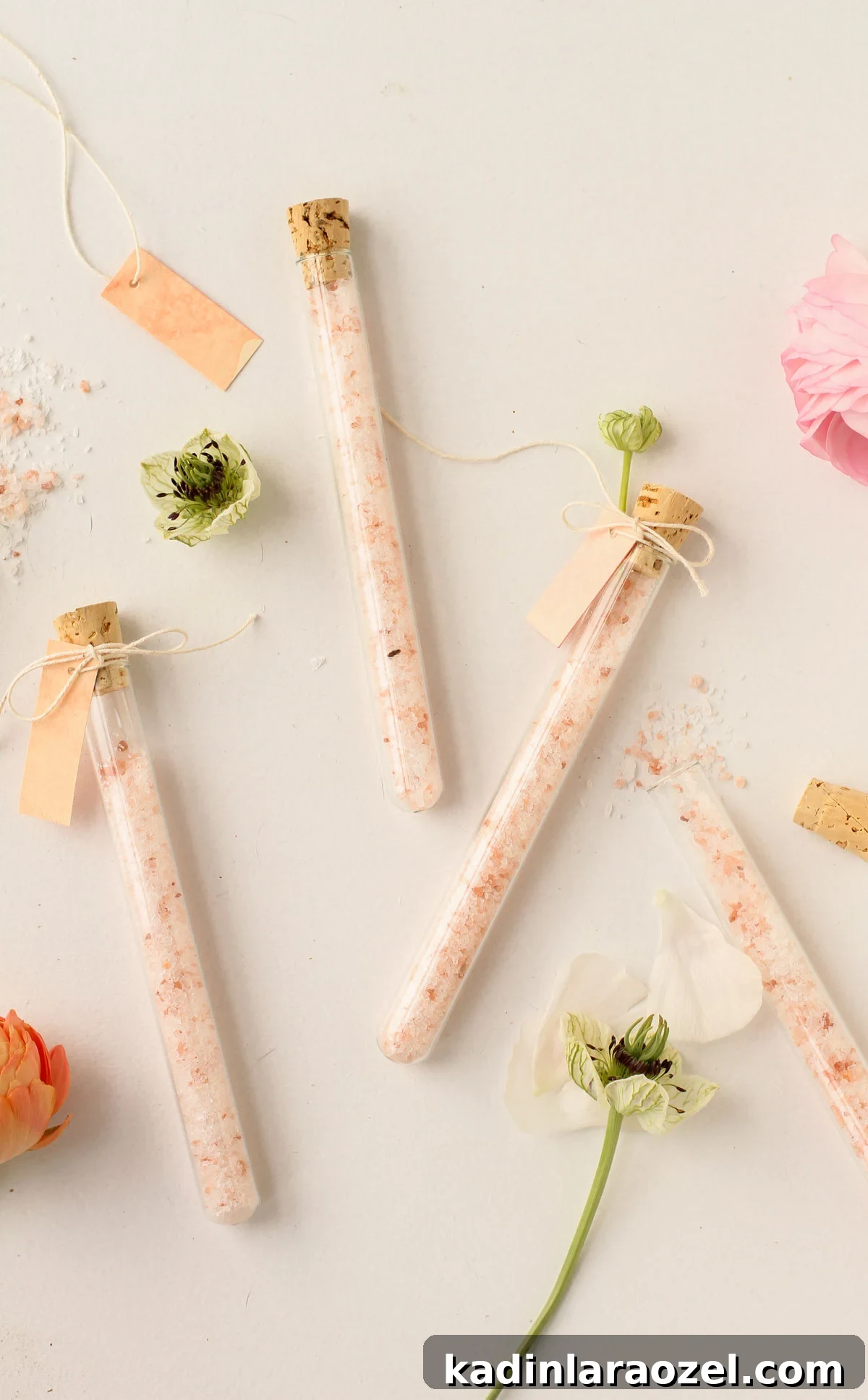 DIY Bath Salts Recipe for Memorable Wedding Favors 2 pink bath salts displayed in skinny glass vials with flowers and cork tops