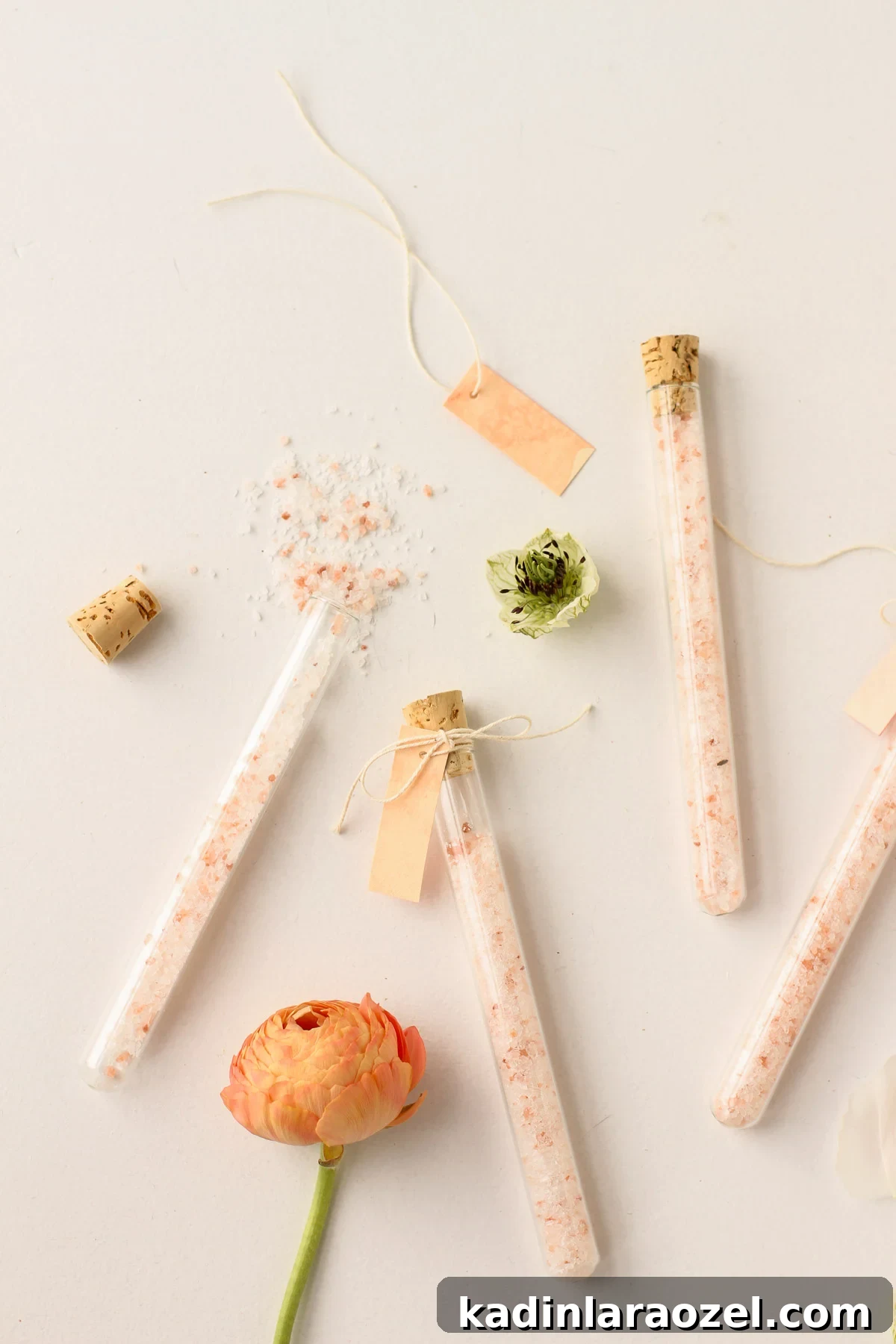DIY Bath Salts Recipe for Memorable Wedding Favors 12 flowers and bath salt vials for a spa day resting on a white countertop