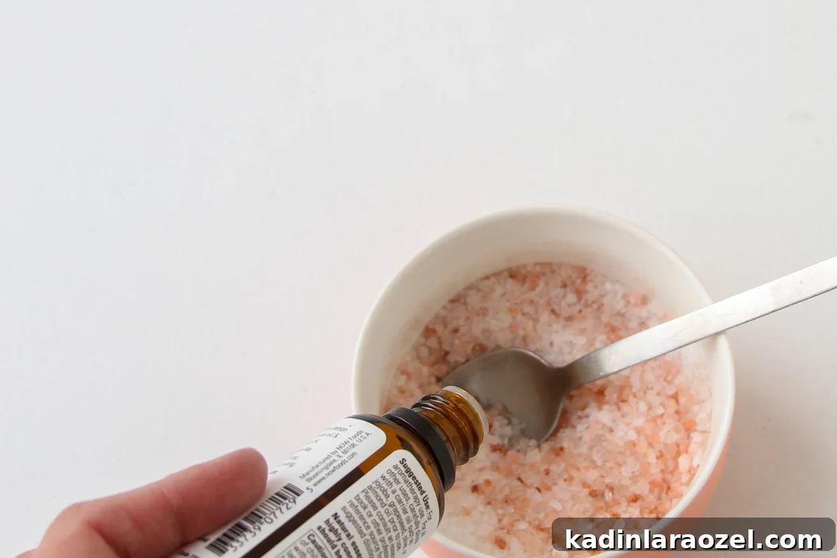 DIY Bath Salts Recipe for Memorable Wedding Favors 6 adding essential oils fragrance to bath slats in a small bowl