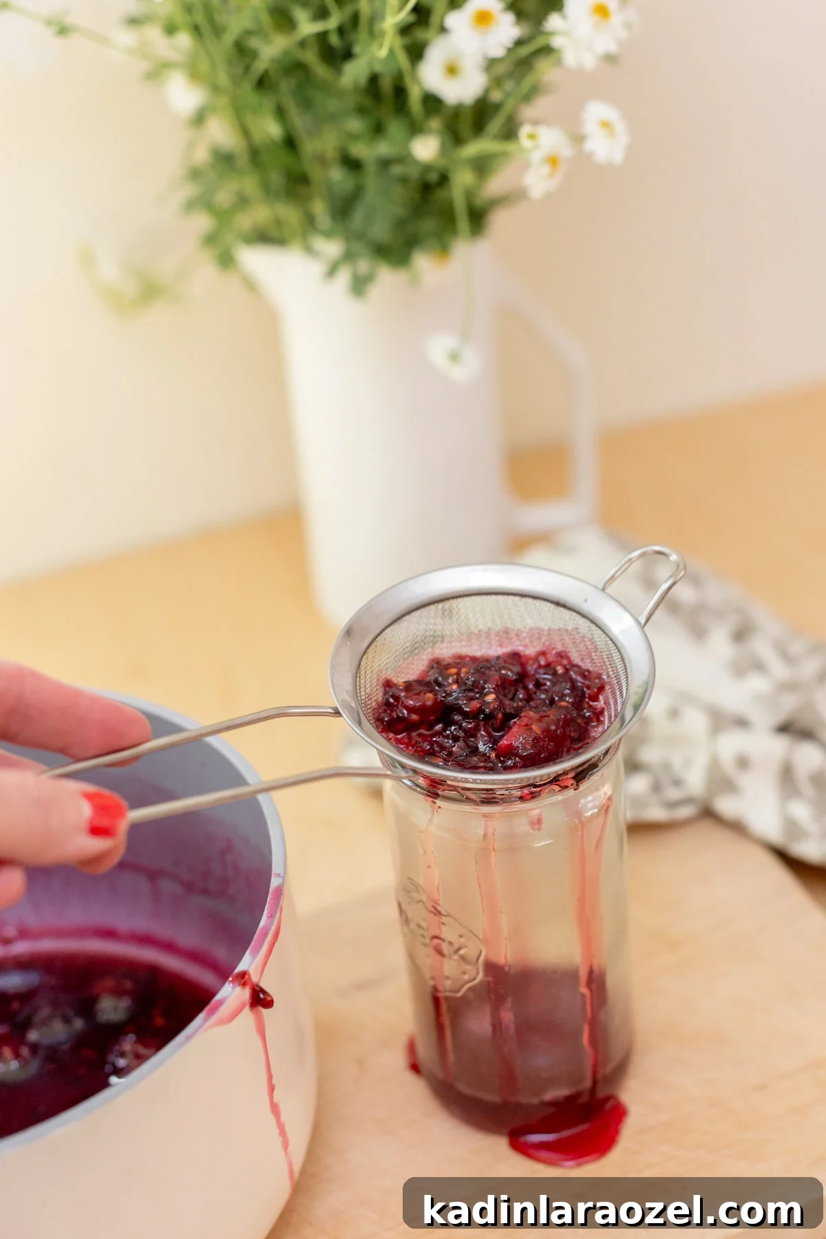 Three-Ingredient Blackberry Syrup Recipe for Pancakes and Desserts 5 straining cooked blackberries into a tall jar to make syrup