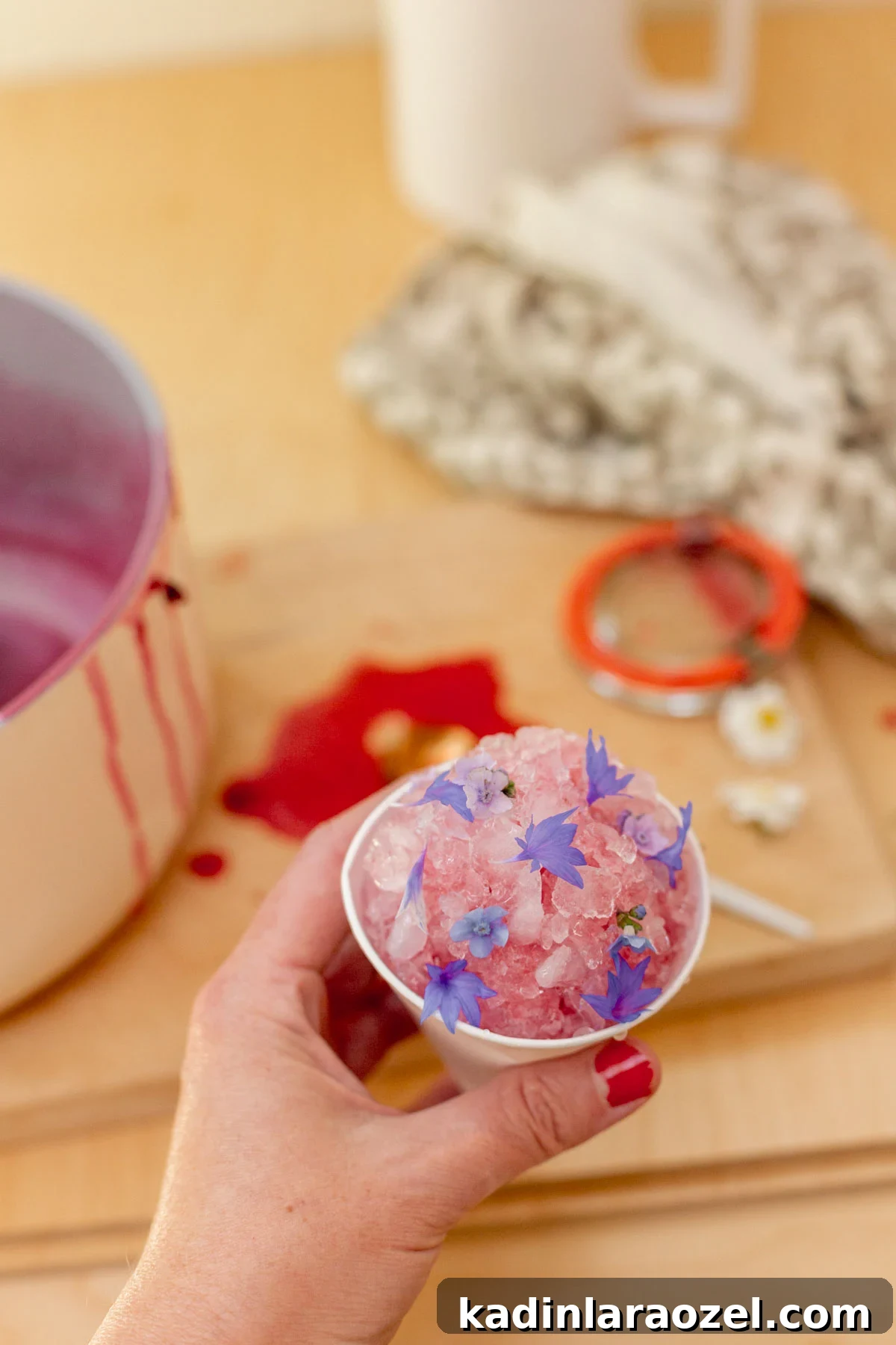 Three-Ingredient Blackberry Syrup Recipe for Pancakes and Desserts 7 woman holding small pink snow cone with edible flowers on top