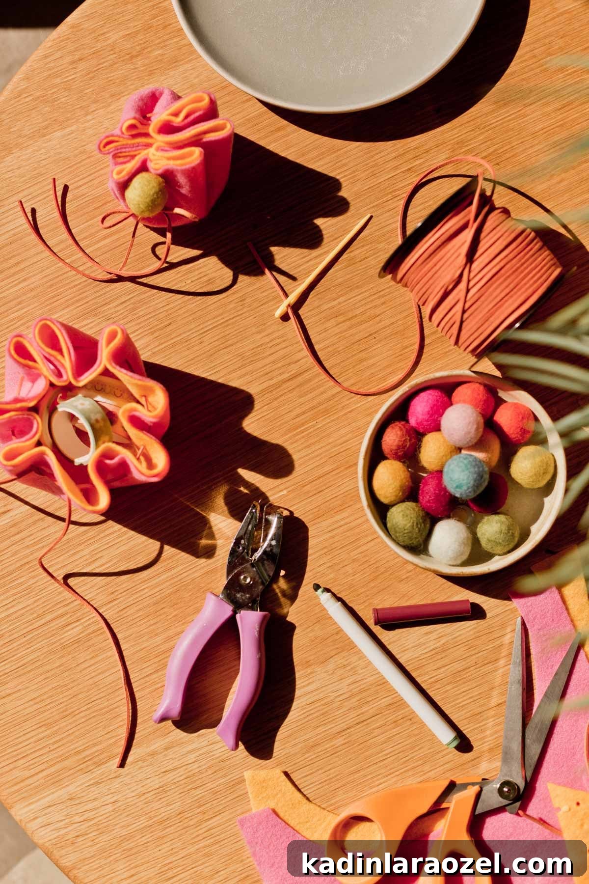DIY Drawstring Pouch: Step-by-Step Sewing Tutorial 10 craft supplies styled on wood table, with felt balls, scissors, cording, and more