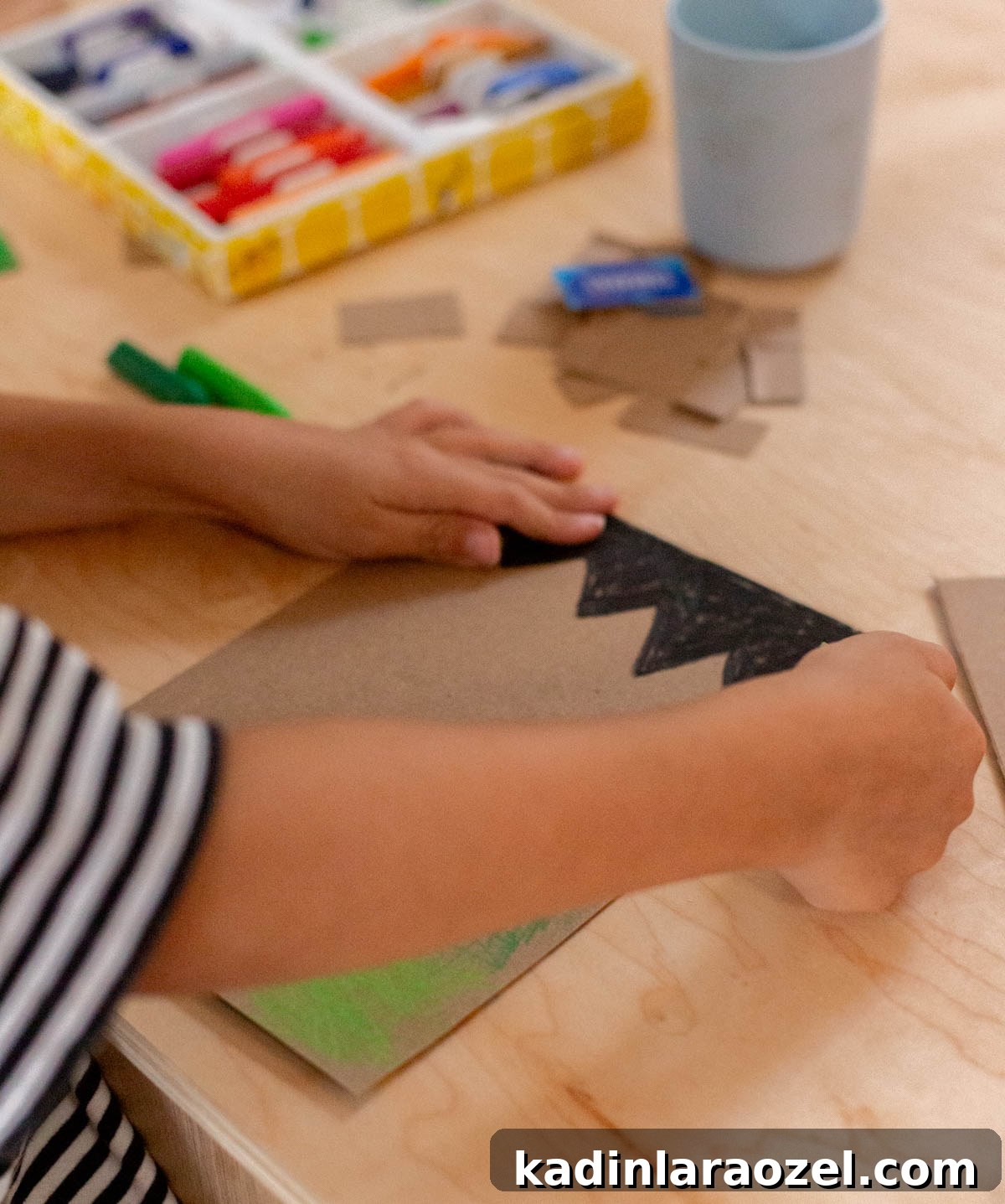 child crafting a halloween dry erase board with cardboard and crayons