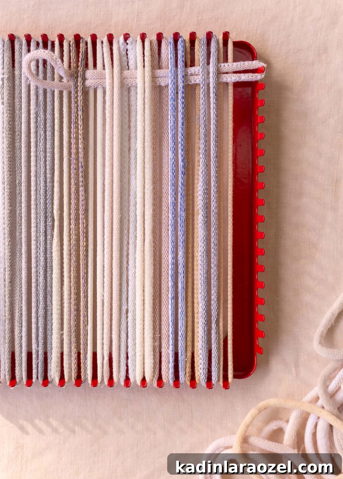 weaving on a potholder loom with neutral cotton loops