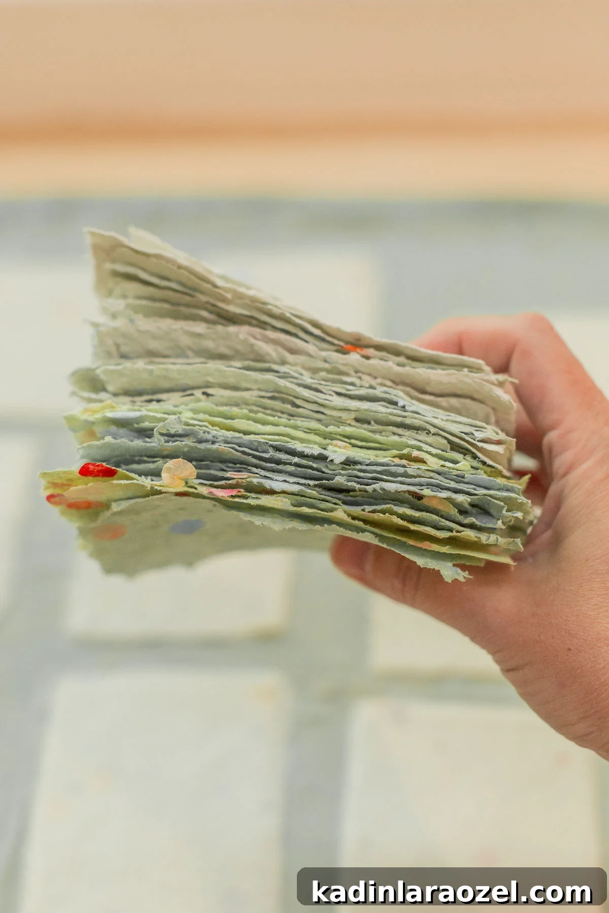 thick stack of homemade paper being held in someone's hand