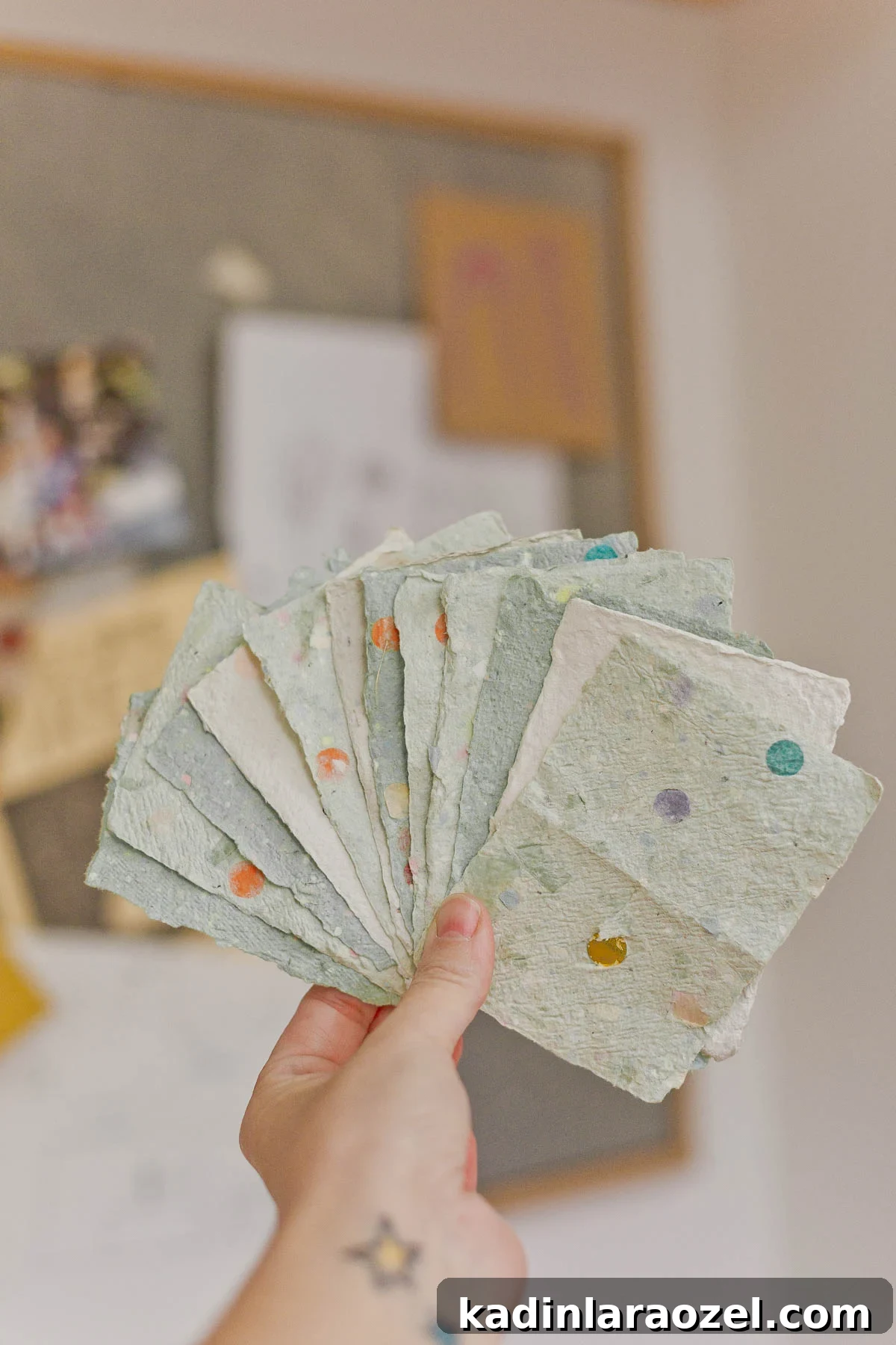 holding up handmade paper in light green color