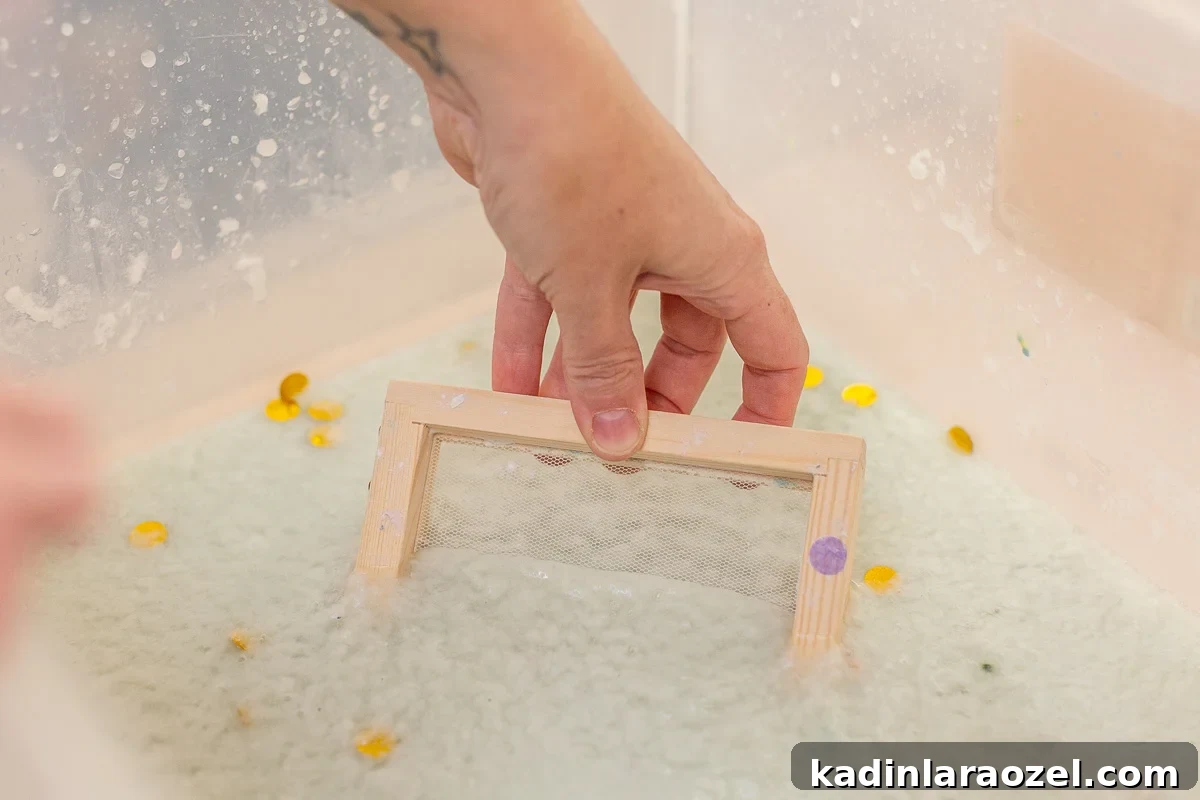 dipping paper mould into paper slurry container to make paper