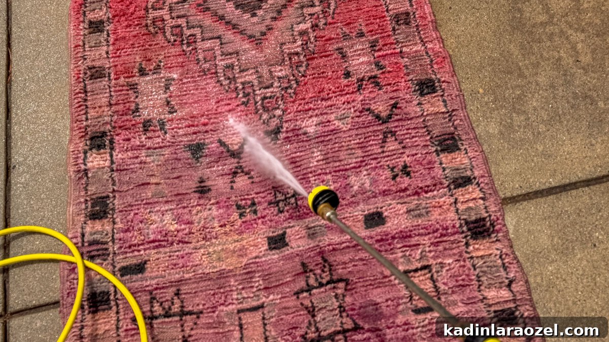 I Pressure Washed a Vintage Moroccan Rug — What Happened Next 4 pink and red rug being washed with a pressure washer outside
