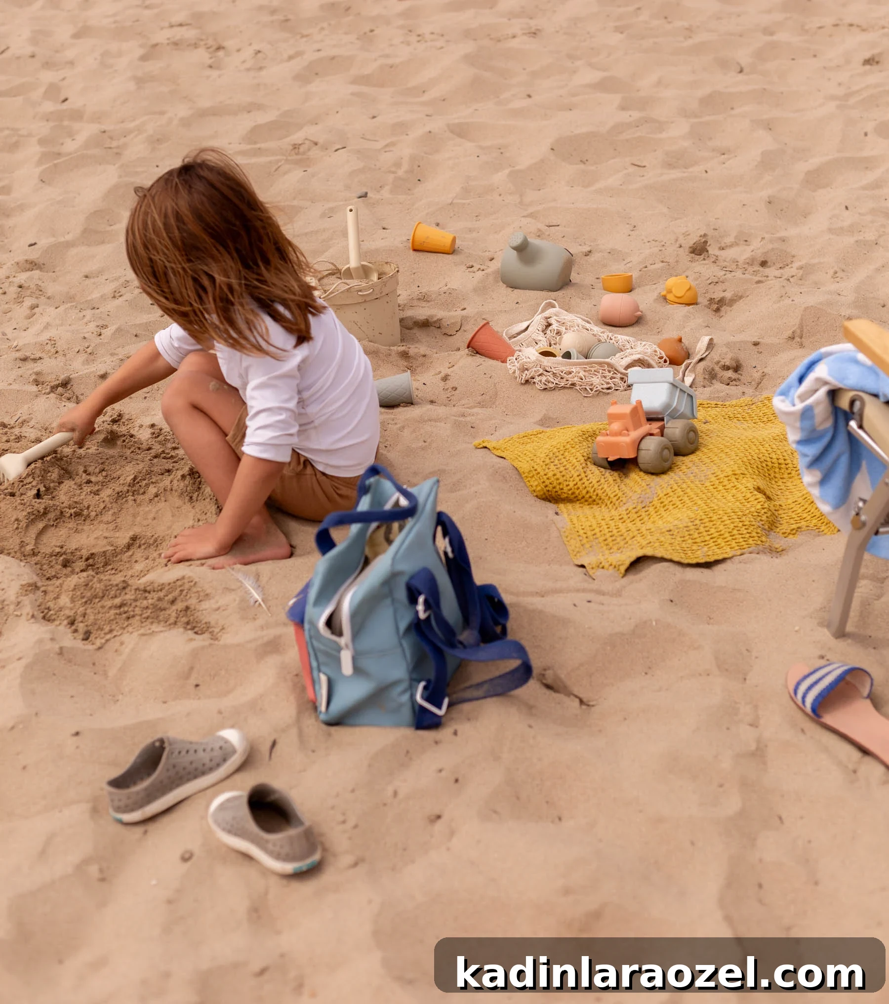 17 Fun Beach Activities for Kids and Families 2 young child playing in sand at beach with neutral sand toys