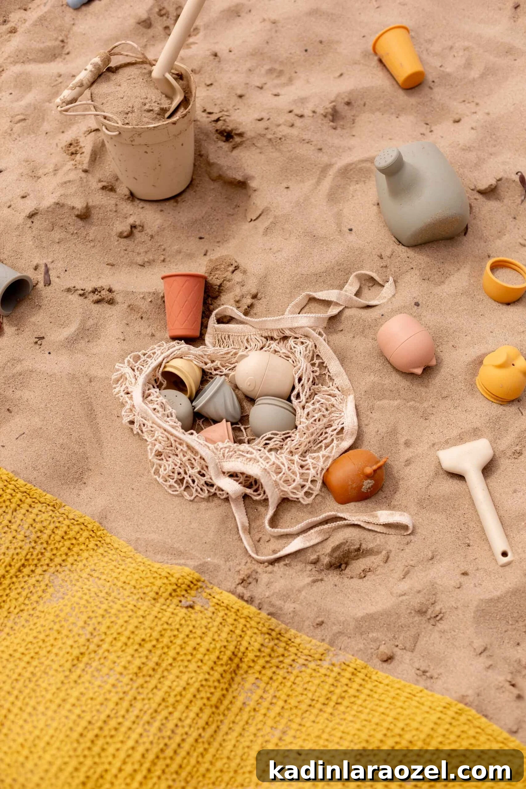 17 Fun Beach Activities for Kids and Families 5 kids sand toys at the beach with colorful towel