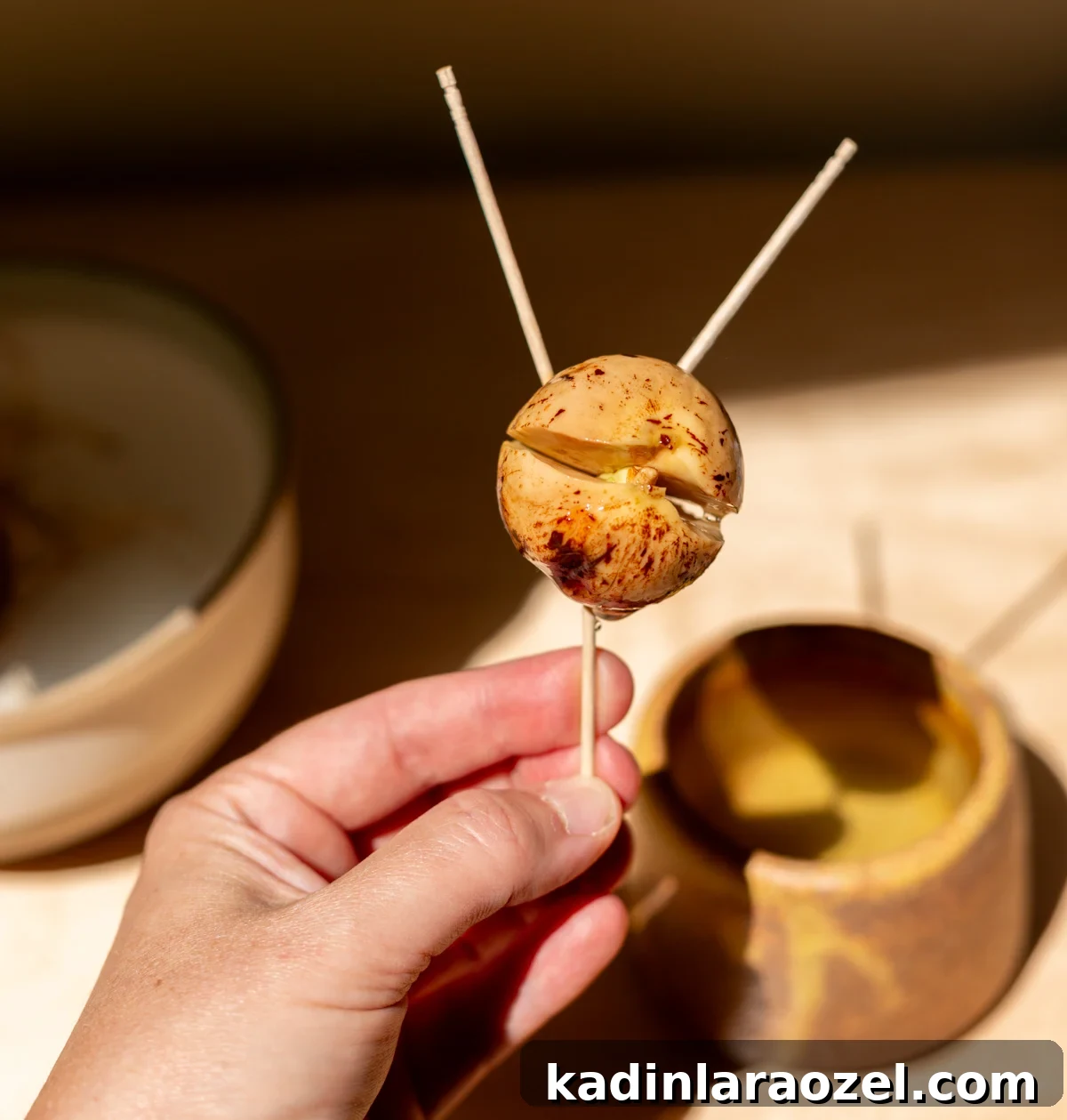 avocado pit split open with three toothpicks stuck in it