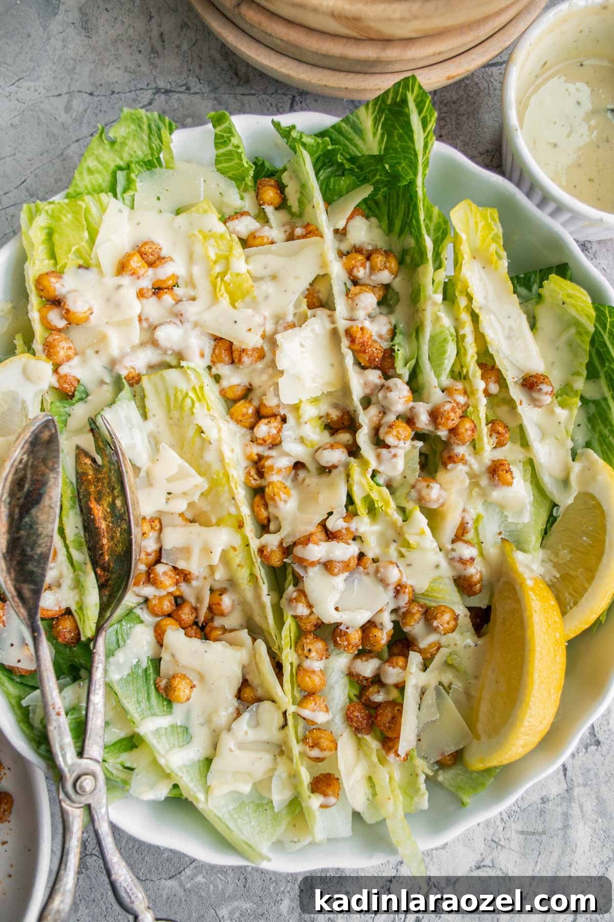 Crispy Roasted Chickpeas Recipe for Snack or Salad Topping 9 crispy chickpeas on top of a caesar salad with dressing and lemon slices