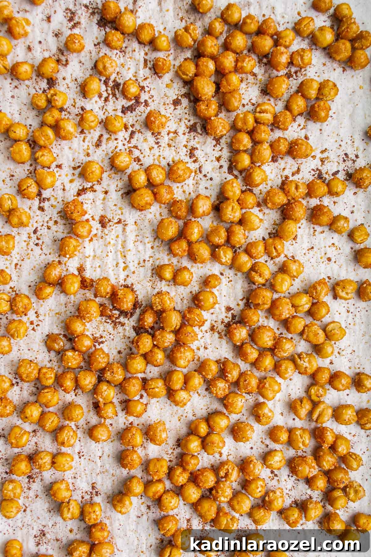 Crispy Roasted Chickpeas Recipe for Snack or Salad Topping 10 crispy roasted chickpeas on a white baking sheet