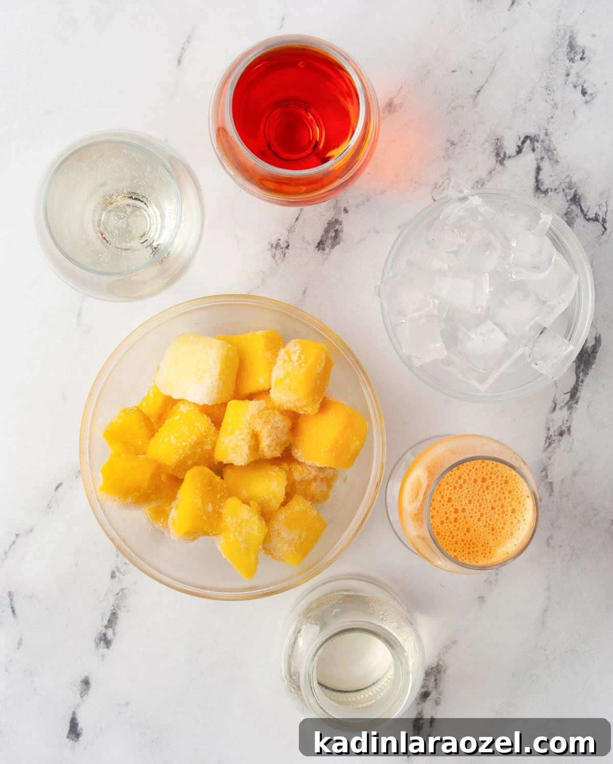 ingredients laid out on marble counter to make a frozen aperol spritz
