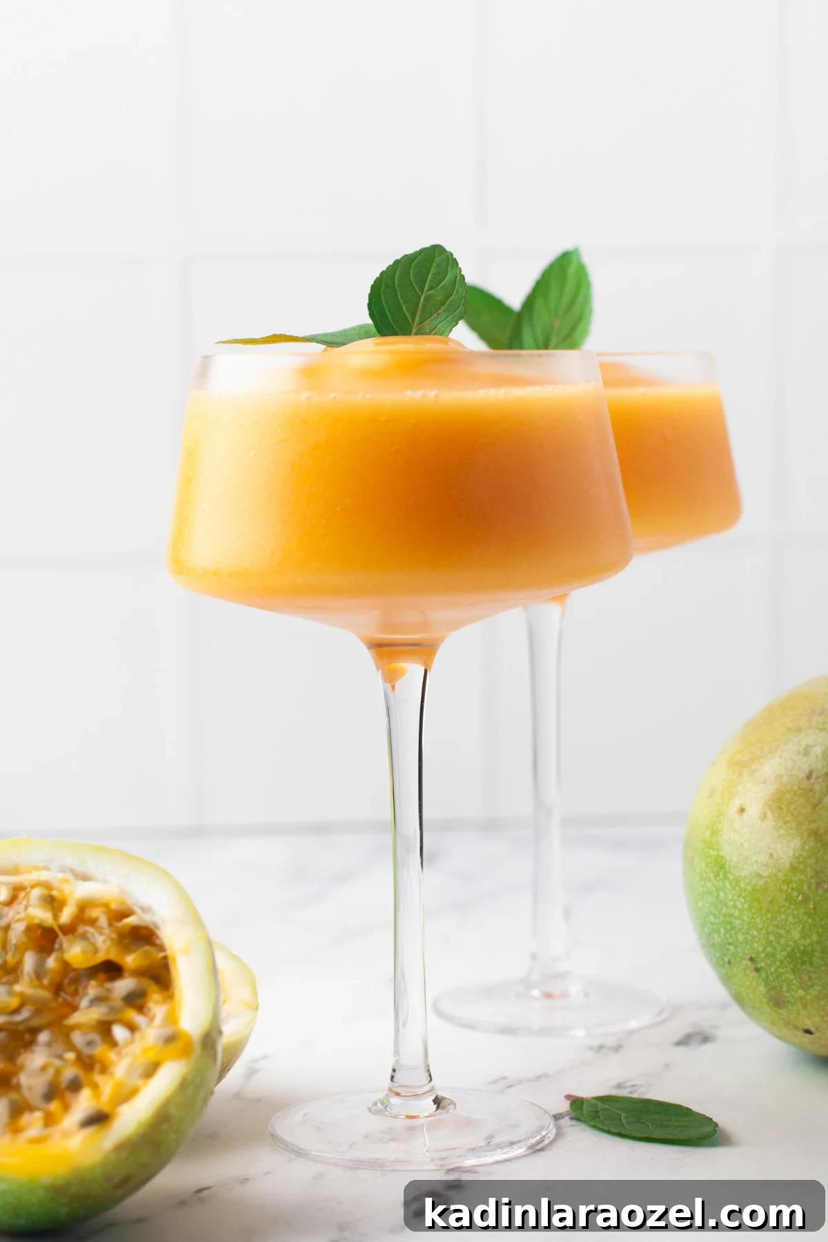 frozen cocktails that are orangish yellow in color with mint sprigs on top