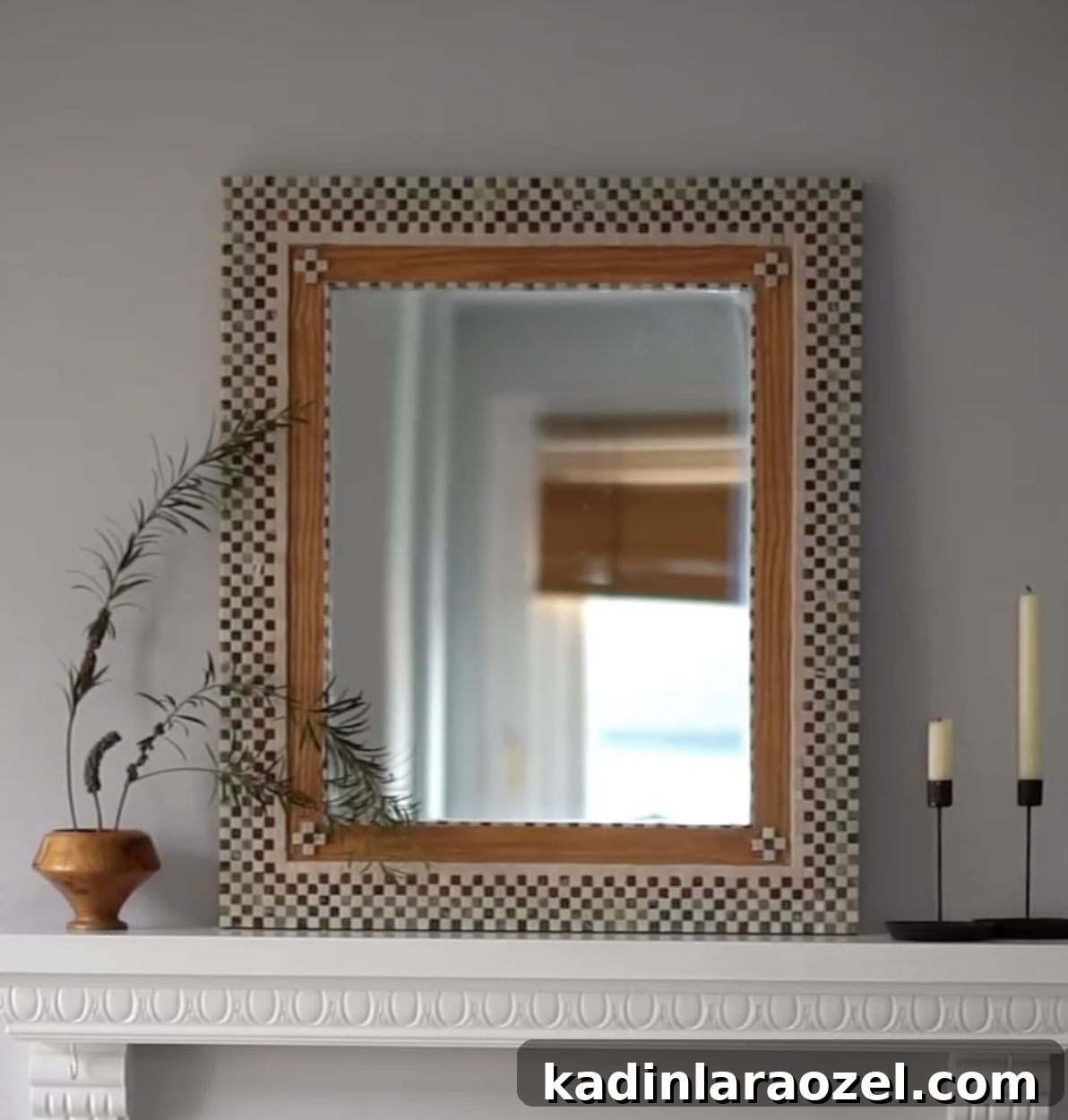 diy tile mirror on a white fireplace with candles and a vase
