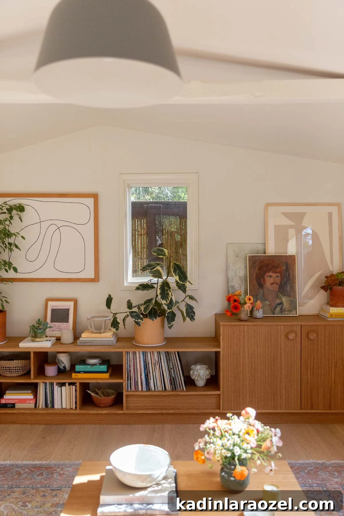 modern wood built in shelving unit in small room with vaulted ceilings and artwork
