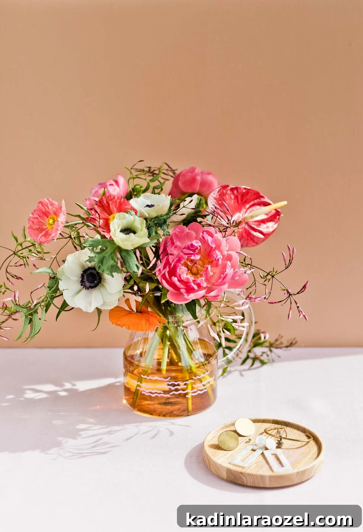 colorful glass pitcher being used as a vase for beautiful bouquet of spring summer flowers