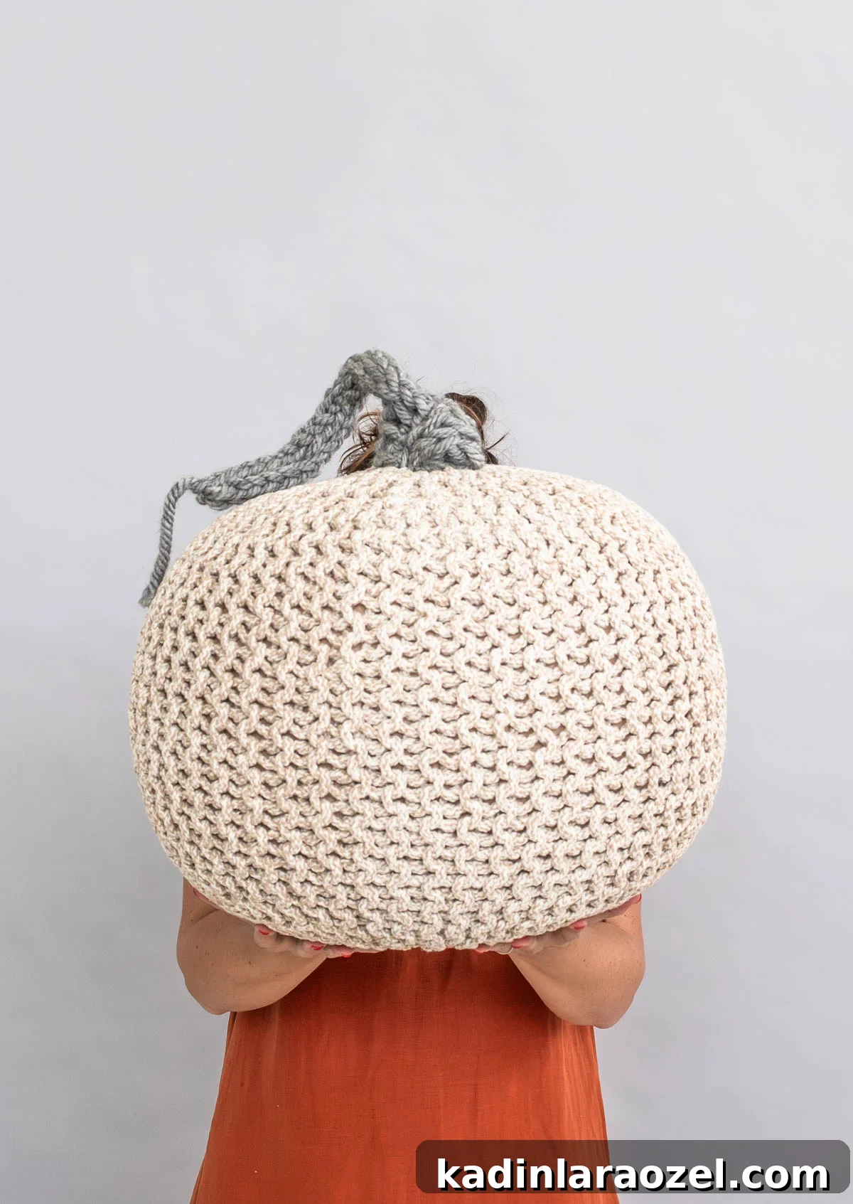 woman holding giant knit pumpkin decor