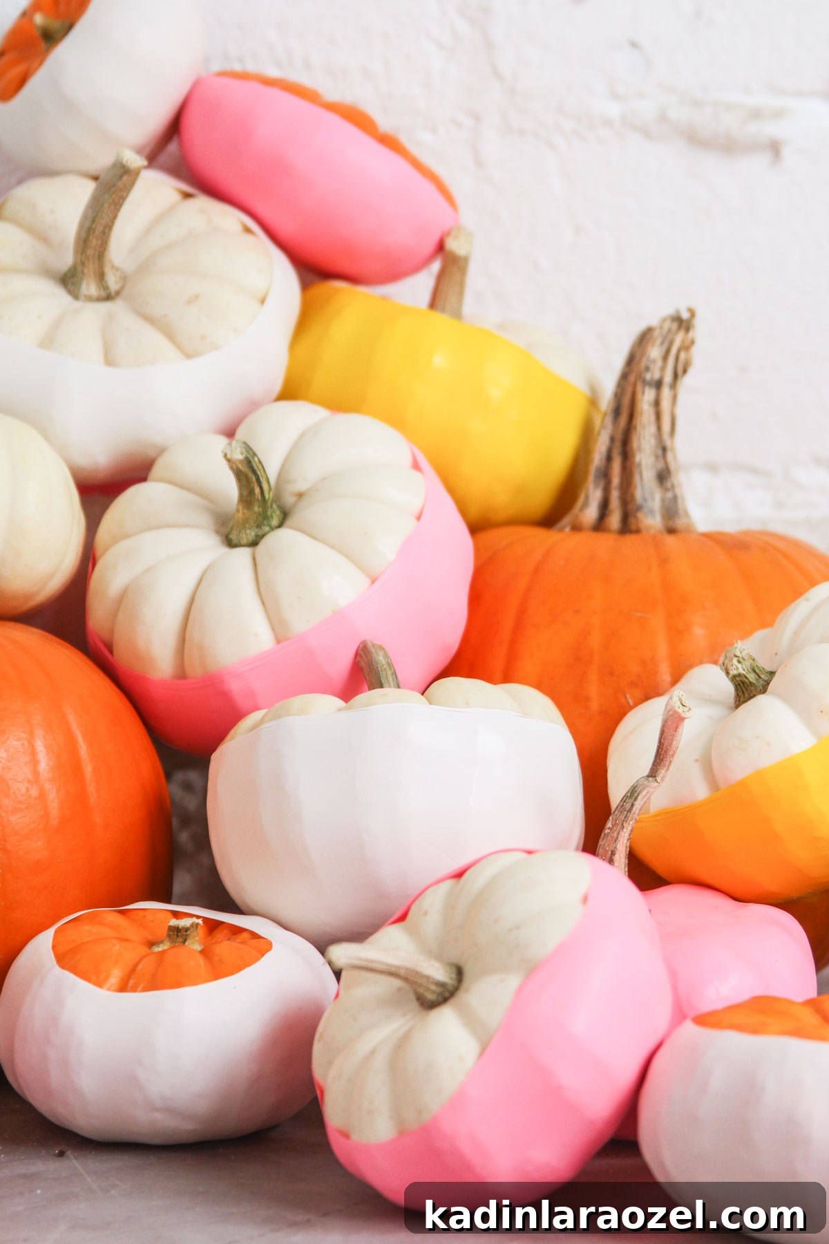 mini pumpkins stacked up and covered with balloons wrapped around pumpkins in neon colors