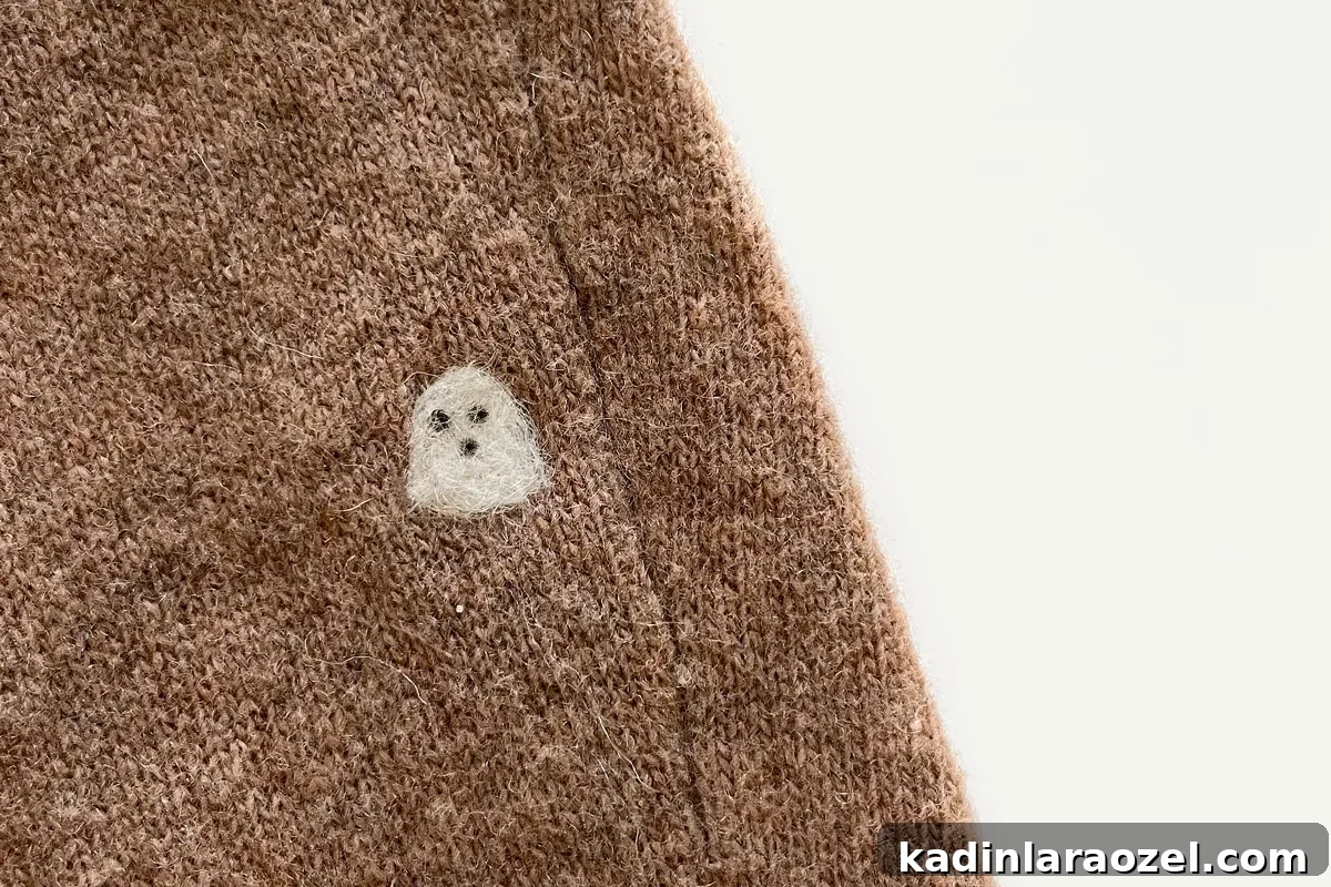 tiny felt ghost on brown sweater