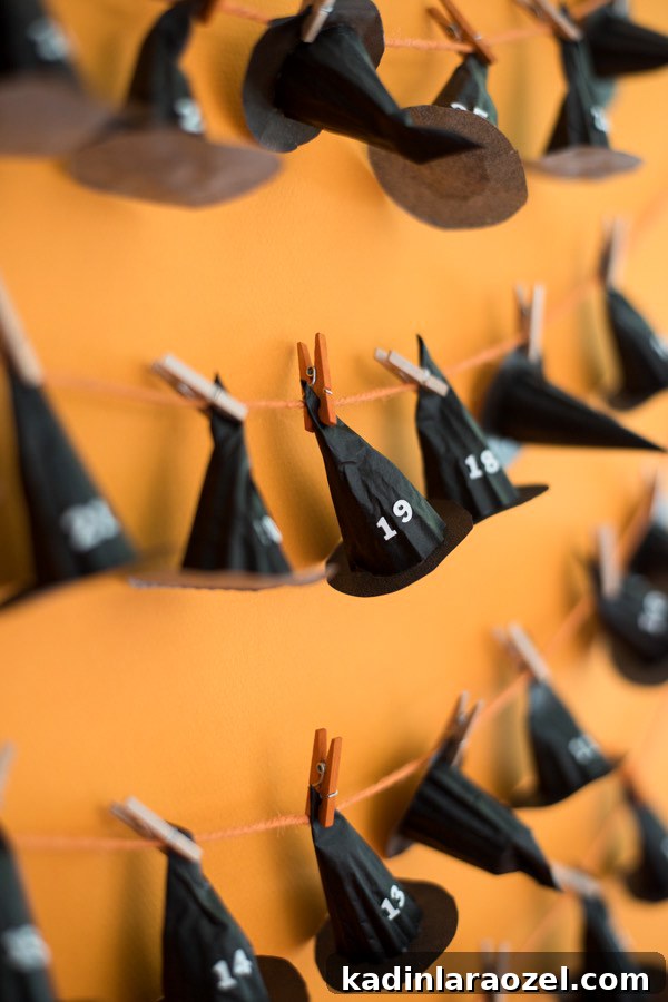 black hats lined up and numbered on a string for a calendar countdown with orange background