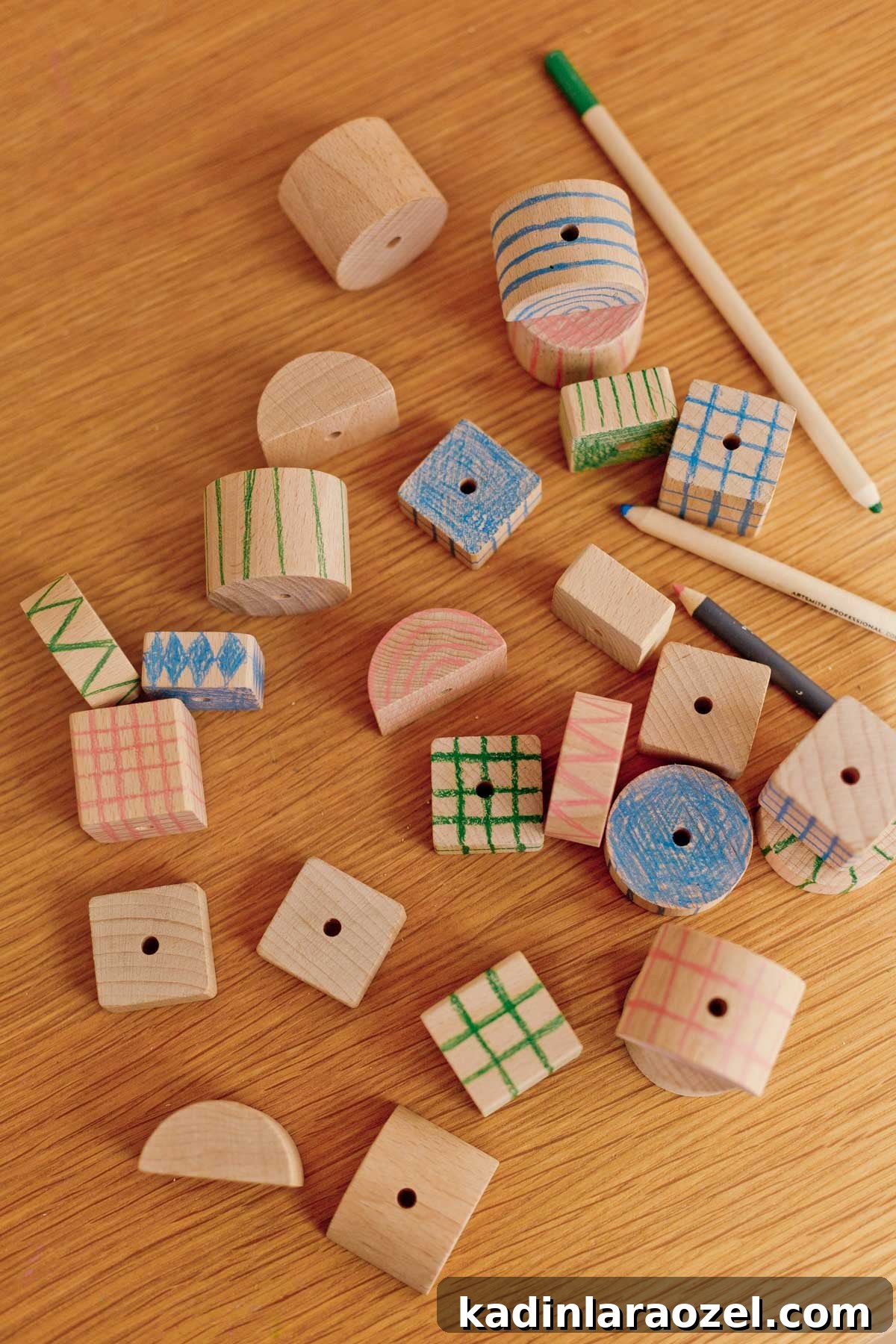 scattered wood blocks on a wood table with colored pencils 