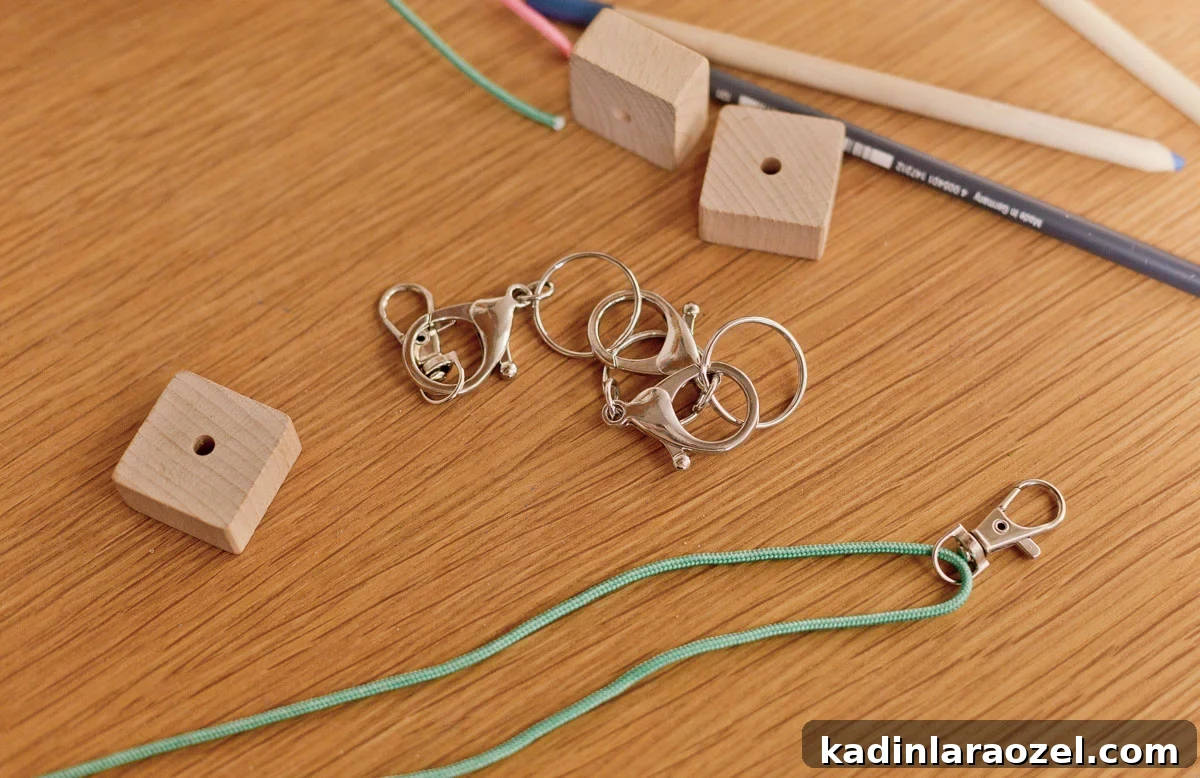 green cording and keychain lobster clasp being threaded onto cord with wood blocks nearby