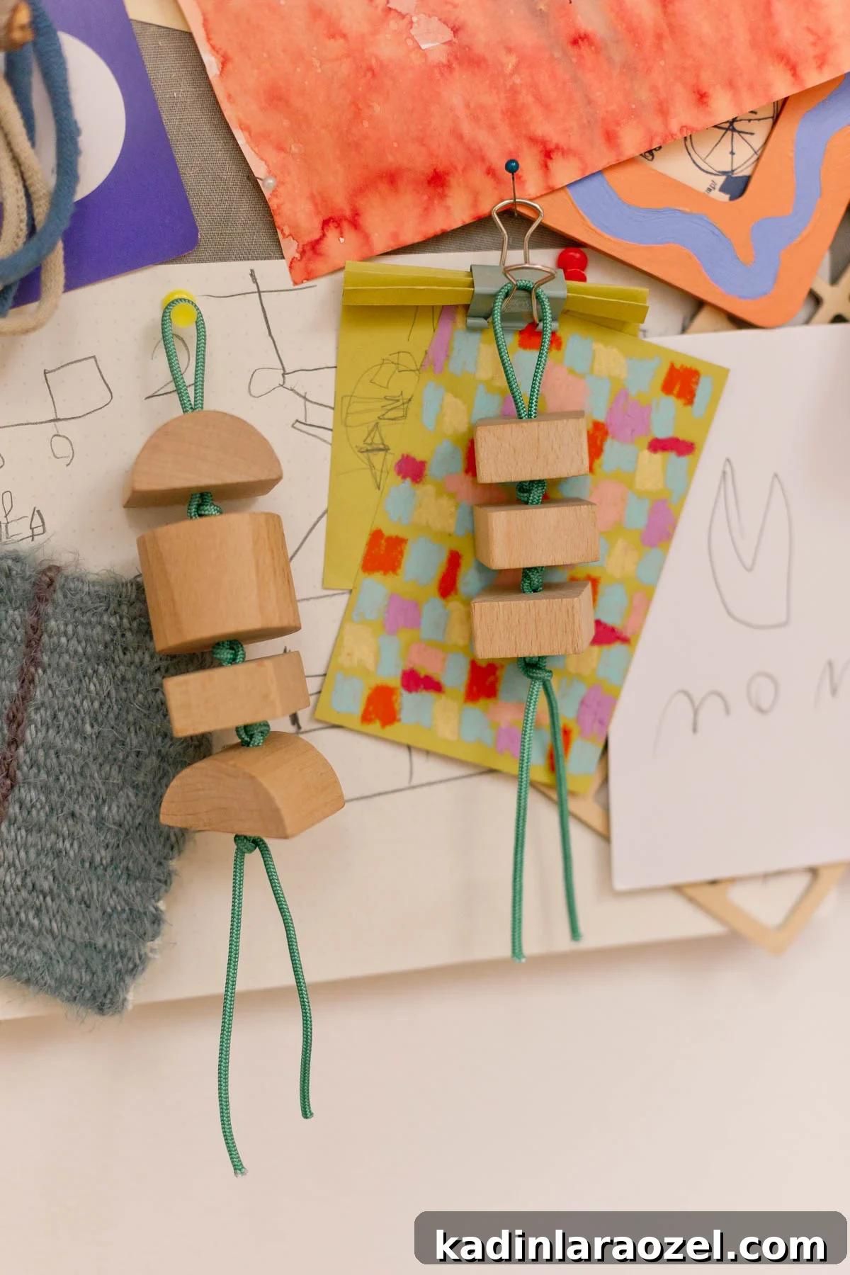 wood keychains hanging from a memo board with art behind it