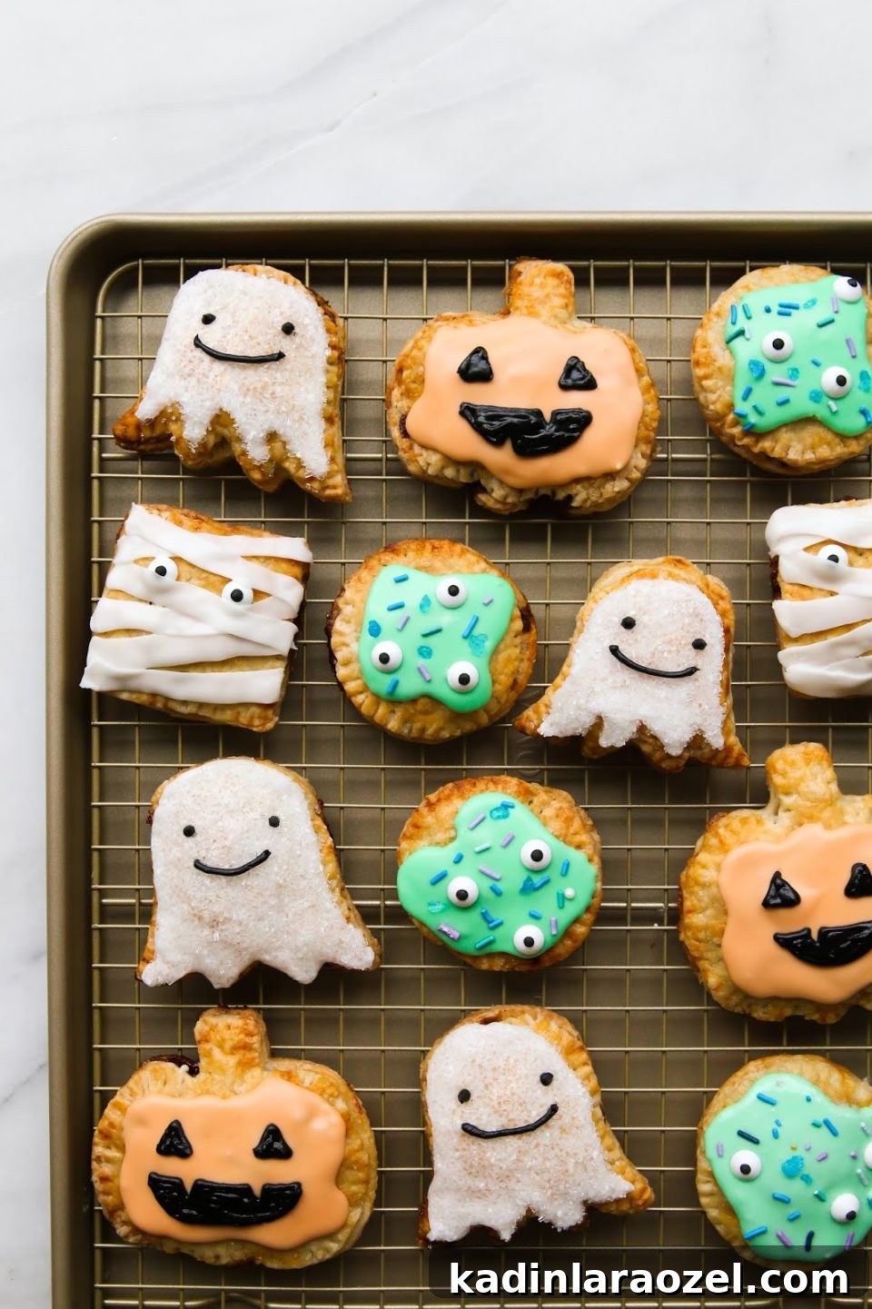 27 Spooky Halloween Desserts to Delight Your Guests 19 cute halloween baked good pop tarts in ghost, monster, and pumpkin shapes