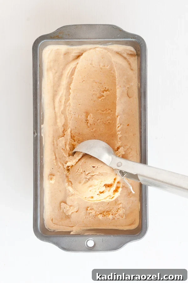 27 Spooky Halloween Desserts to Delight Your Guests 26 scooping pumpkin ice cream from a metal tin