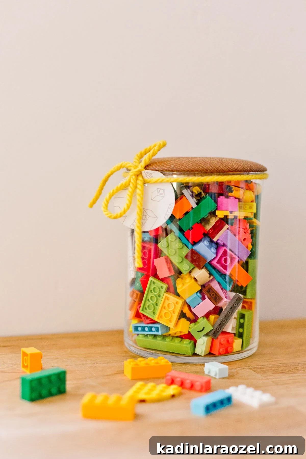 glass jar with wood lid, filled with colorful legos for kids