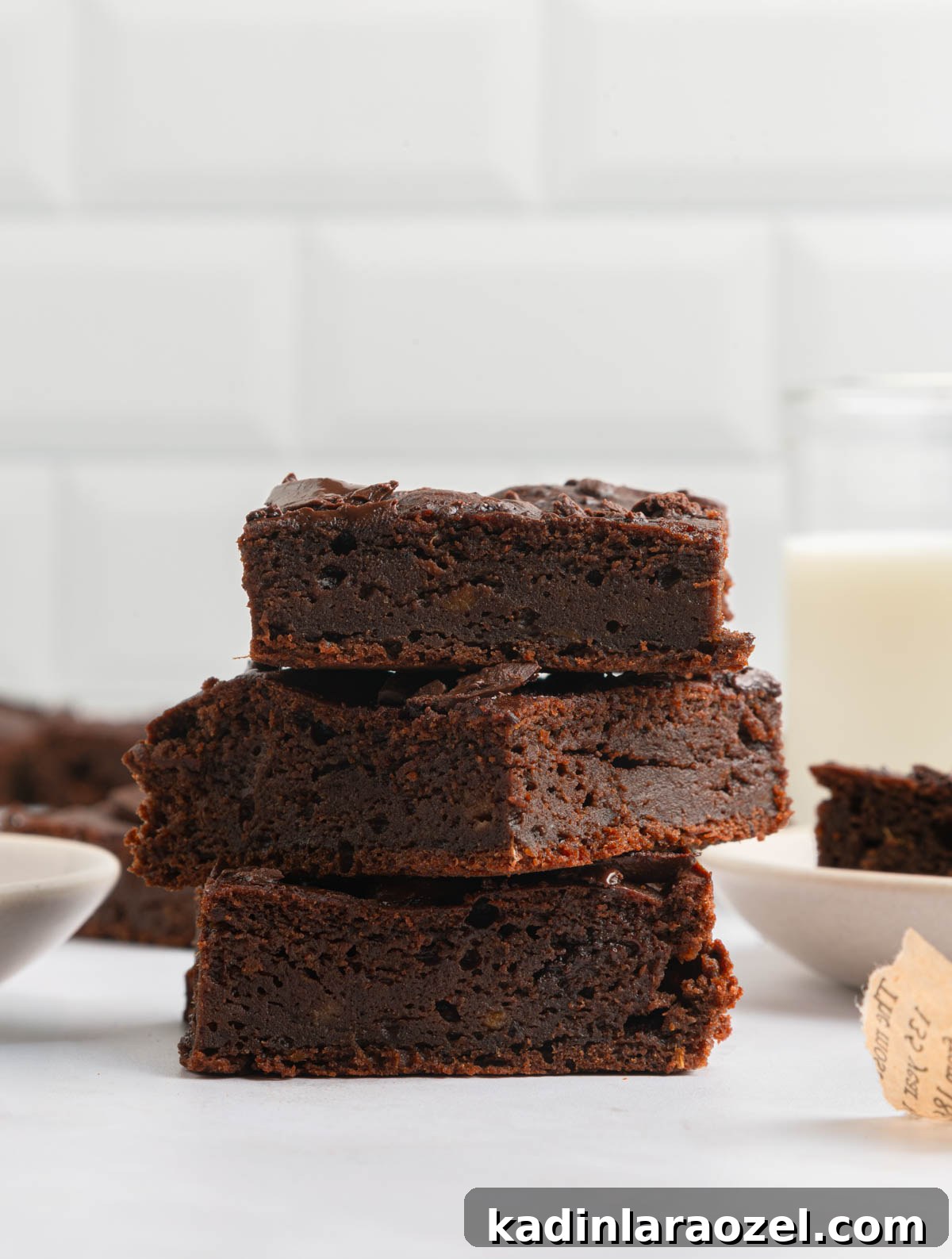 fudge-y rich brownies stacked on top of each other in a white kitchen