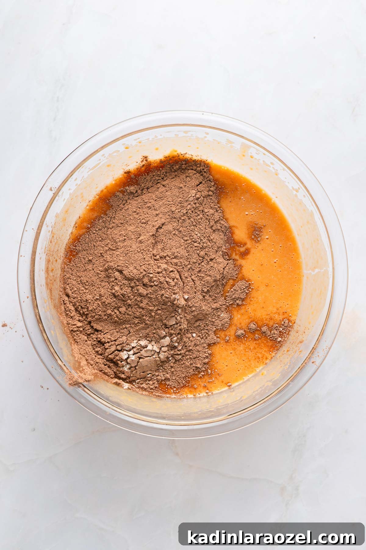 ingredients being mixed in a bowl for brownies, cocoa powder, sweet potatoes, and more