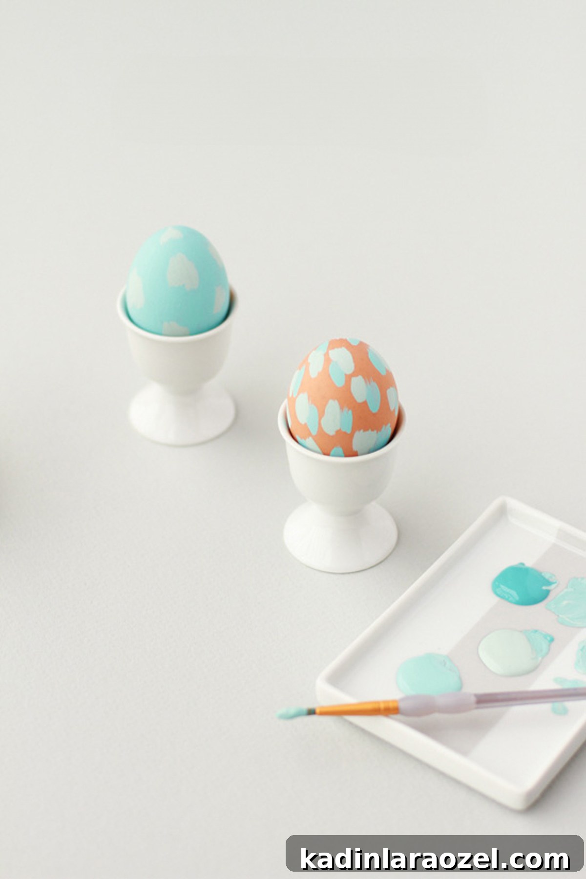 two painted easter eggs with abstract pastel blue patterns