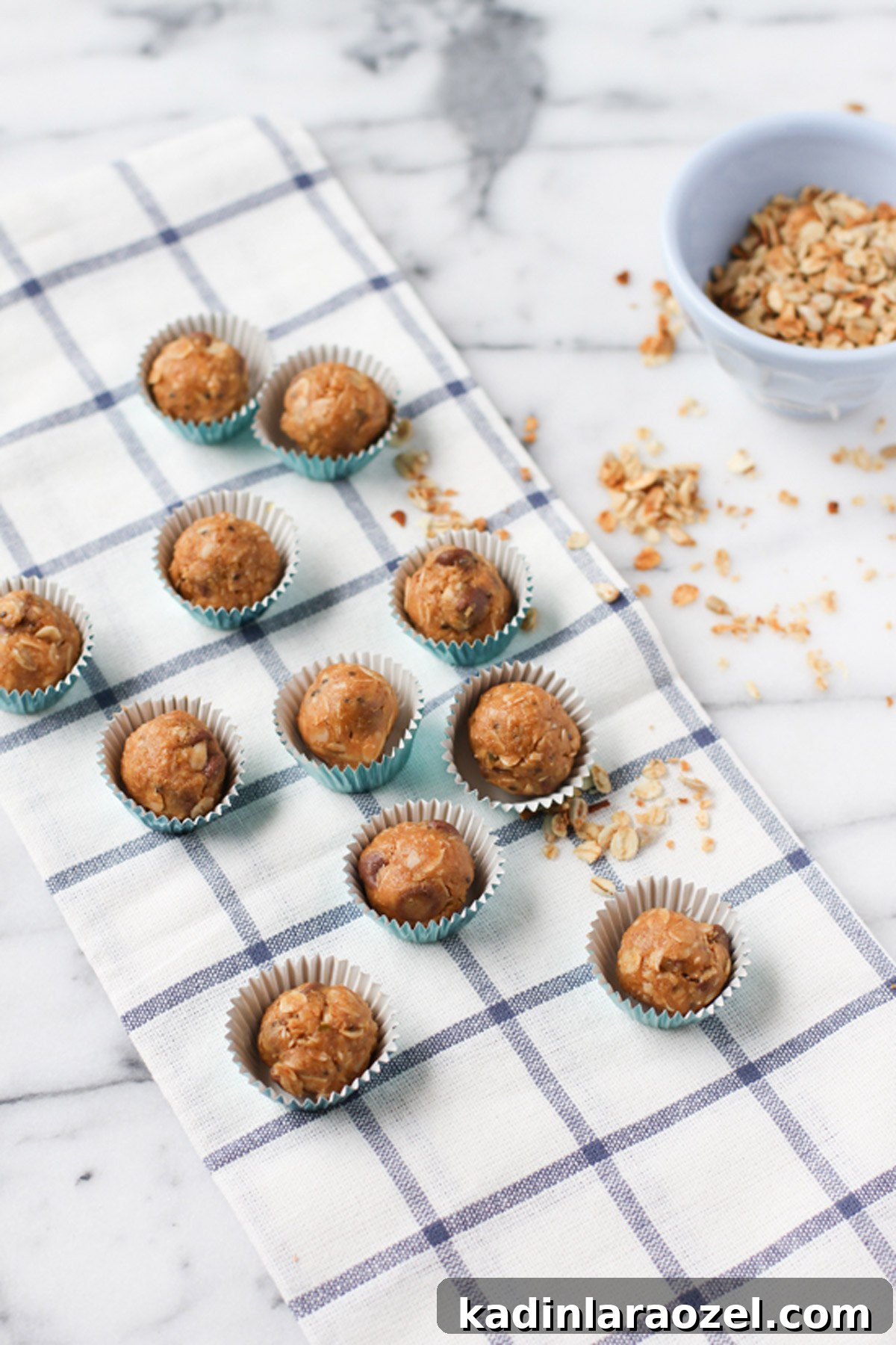 Organic Peanut Butter Protein Balls — Quick No-Bake Snack 2 Peanut butter energy balls on white and blue tea towel on marble countertop