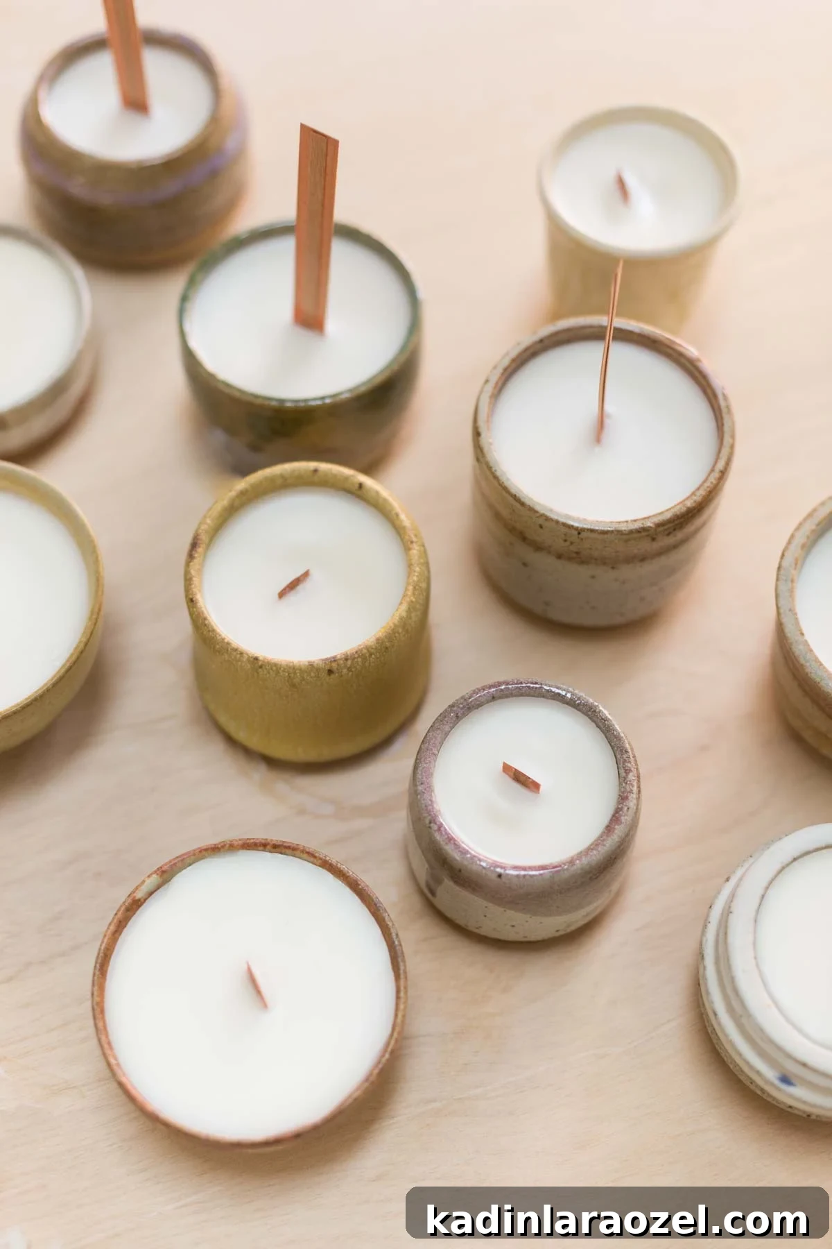Complete Guide to Crafting Soy Candles at Home 8 DIY soy candles in various stages of completion, sitting on wood surface