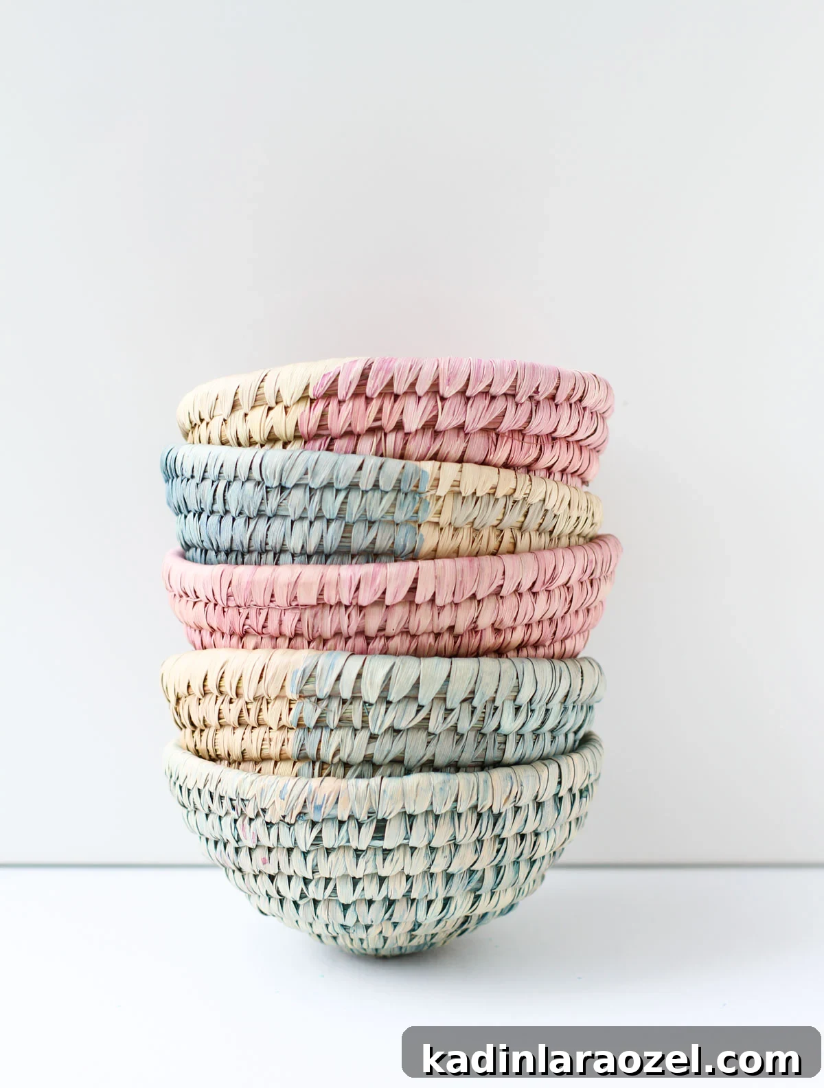 10-Minute Dip-Dyed Woven Baskets DIY Tutorial 2 Small woven baskets stacked on top of each other in pink and blue colors