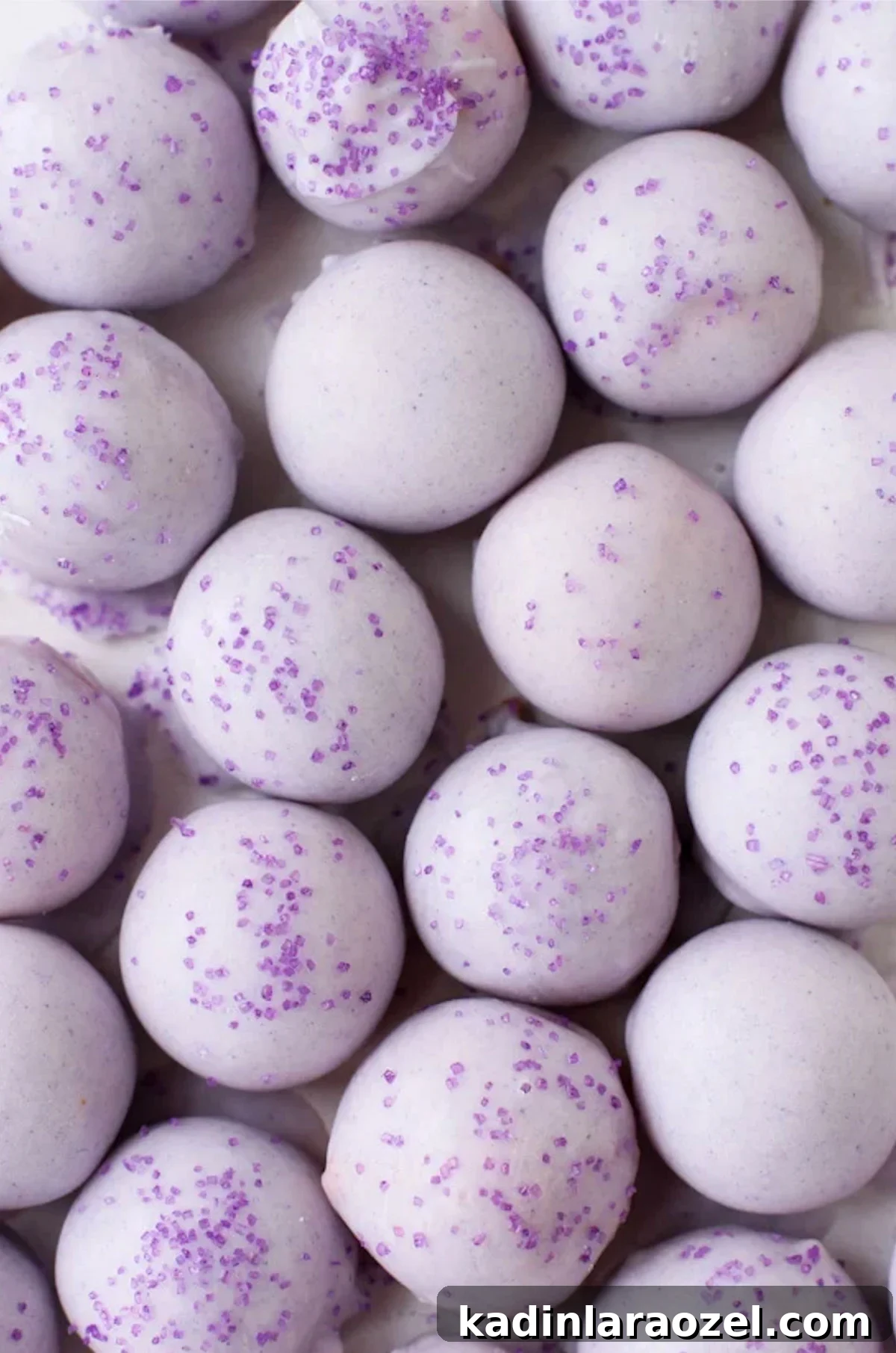 pastel purple cake balls with chocolate coating and sprinkles on top