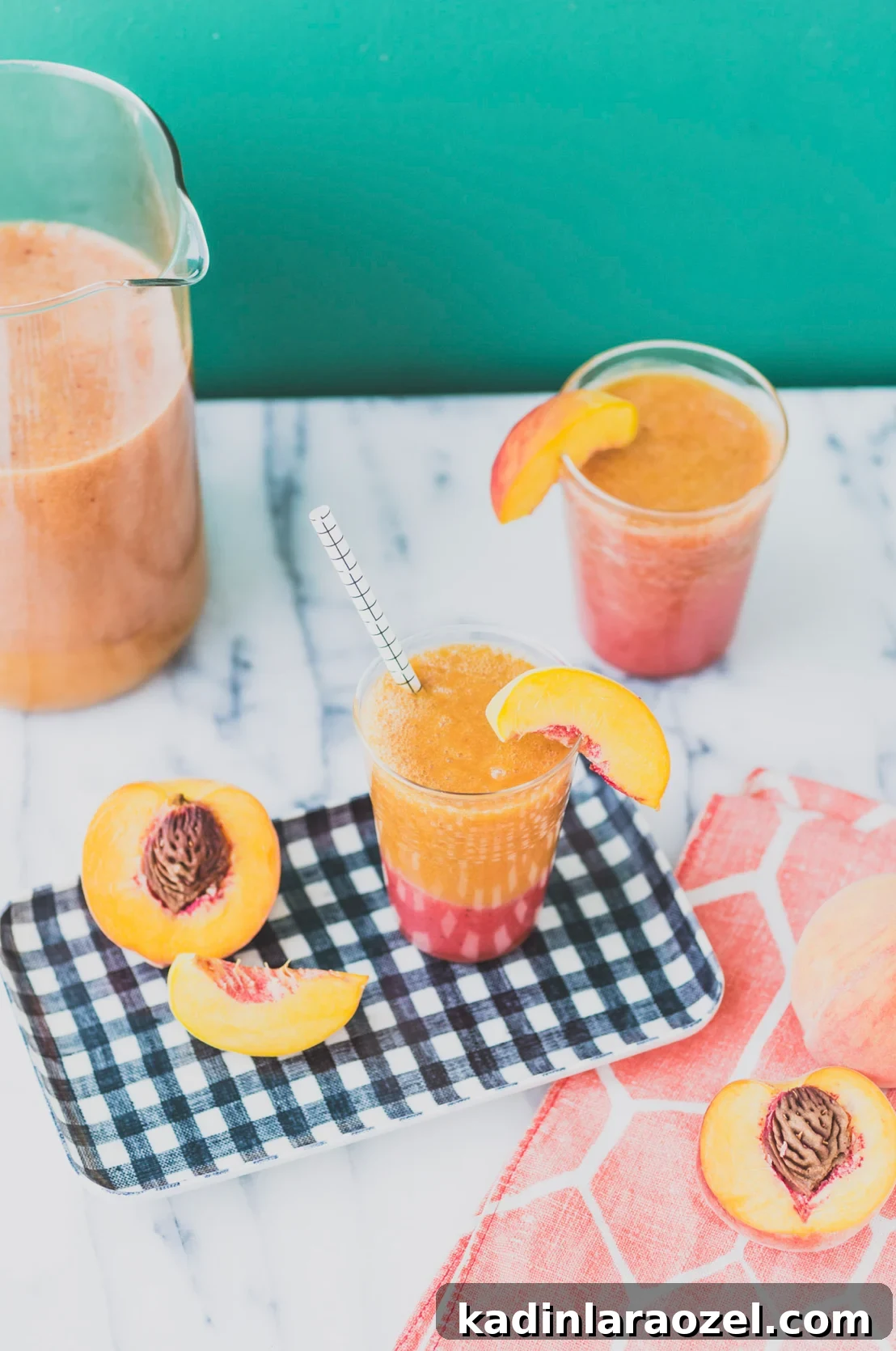 Peach cocktails mixed on a marble countertop, with black and white tray.
