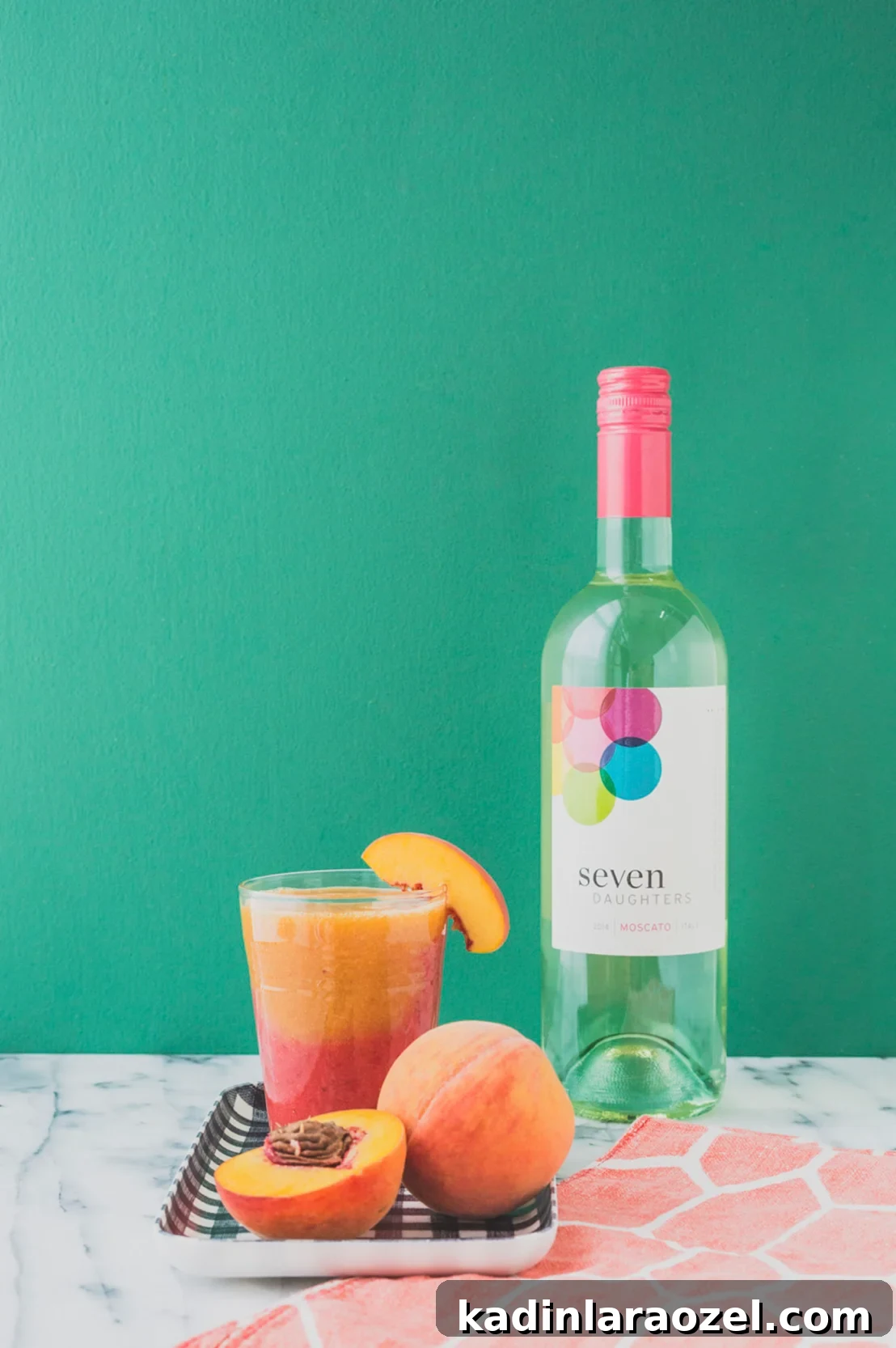 A frozen cocktail sits on a kitchen counter with a wine bottle behind it.