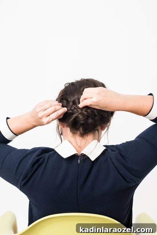 Quick Reverse Crown Braid Tutorial: Stylish Look in 15 Minutes 6 Woman pinning her braids into a low crown braid updo