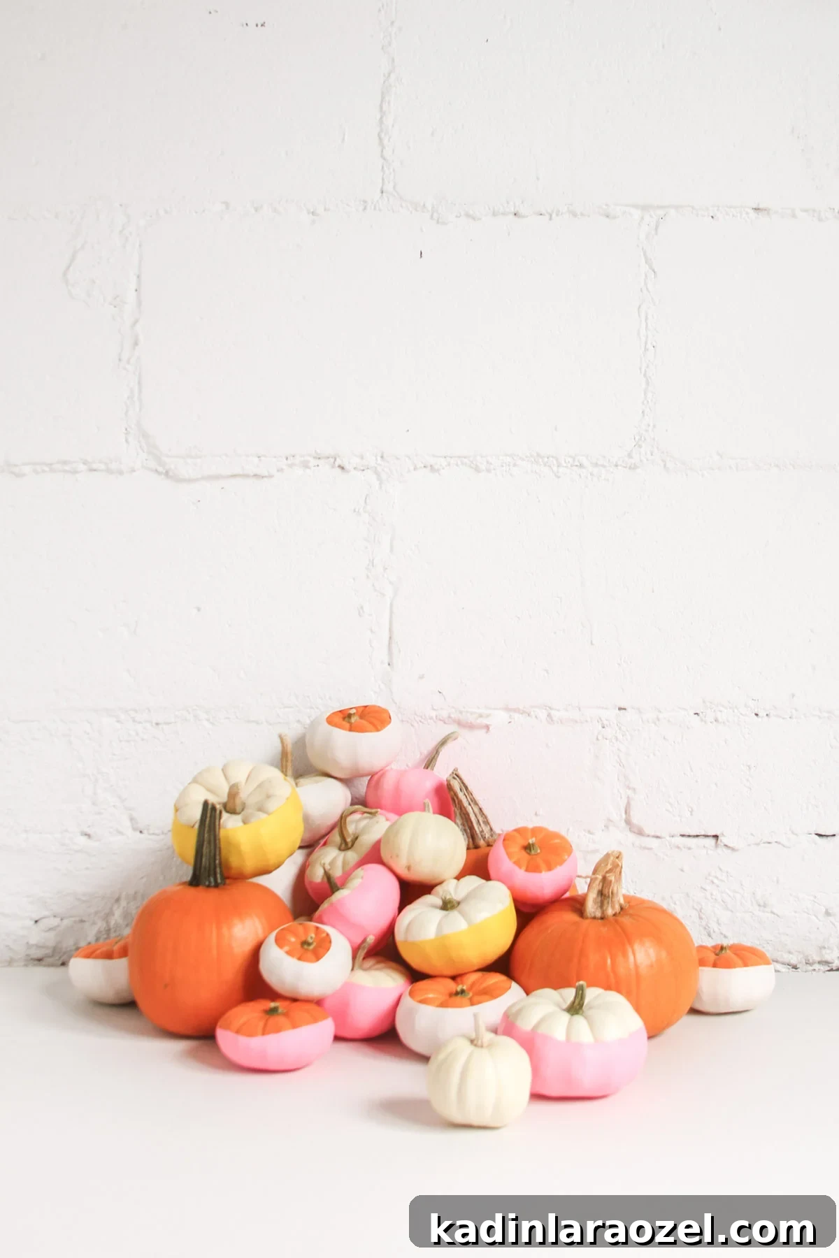 Small balloon dipped pumpkins, in warm colors, with white background.